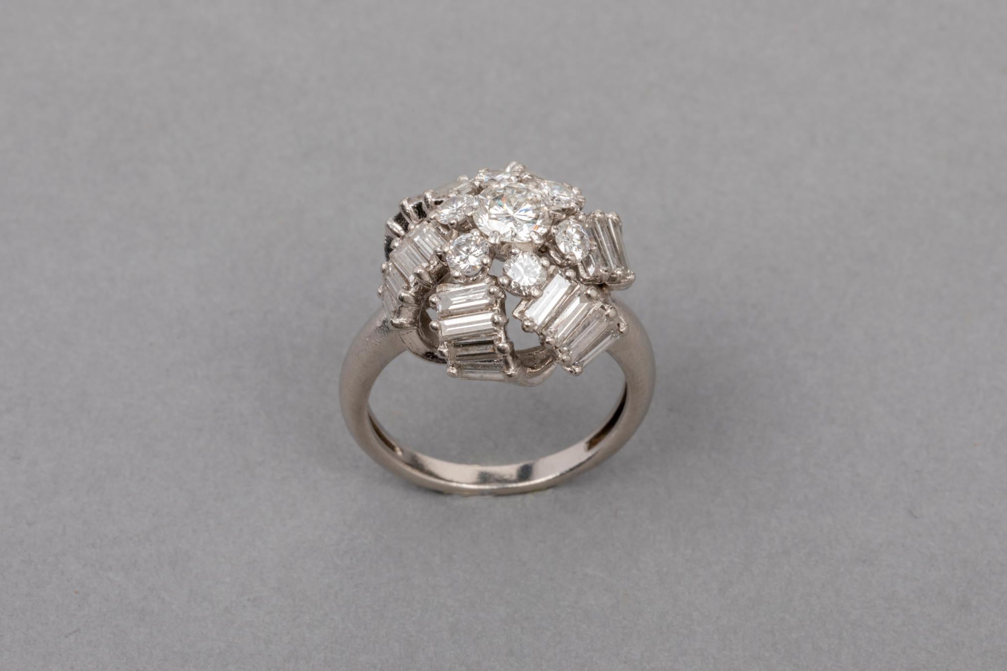 Very beautiful ring, made in France circa 1960.
Made with platinum (dog mark) and high quality diamonds. F/G colour and Vs clarity.
The central diamonds weights 0.45 carats estimate 
The 6 others around  weights 0.55 total estimate.
The 24 baguettes
