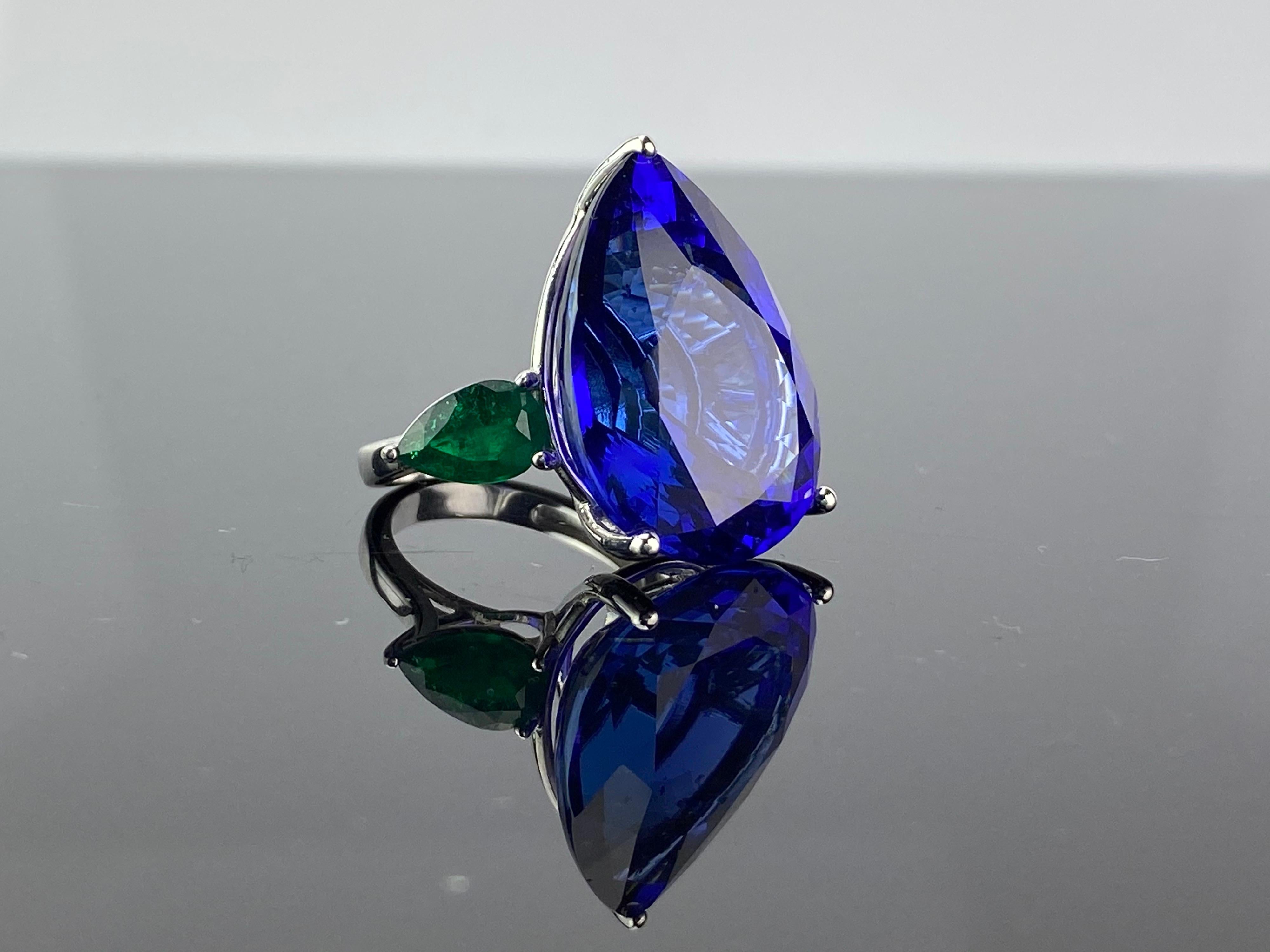 Make a statement with this exceptional pear shaped, 32.05 carat AAA blue Tanzanite cocktail ring, with pear shaped 1.93 carat Zambian Emerald side stones. The color combination of the blue Tanzanite and green Emerald makes this ring very unique. The