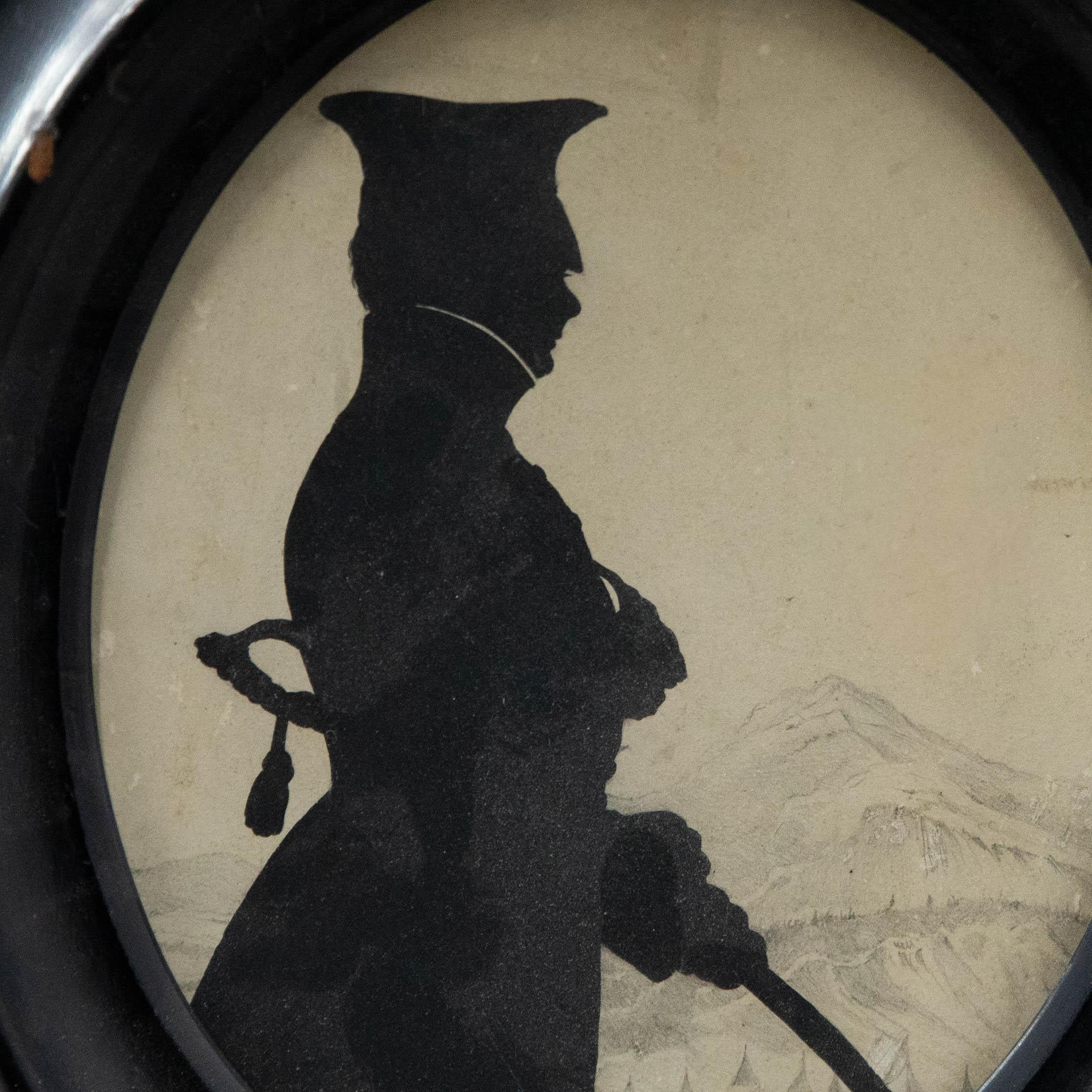 Charmante étude de silhouette d'un soldat armé devant un paysage alpin dessiné à la mine de plomb. Non signée. Bien présenté dans un cadre ovale en laque noire. Sur le papier.