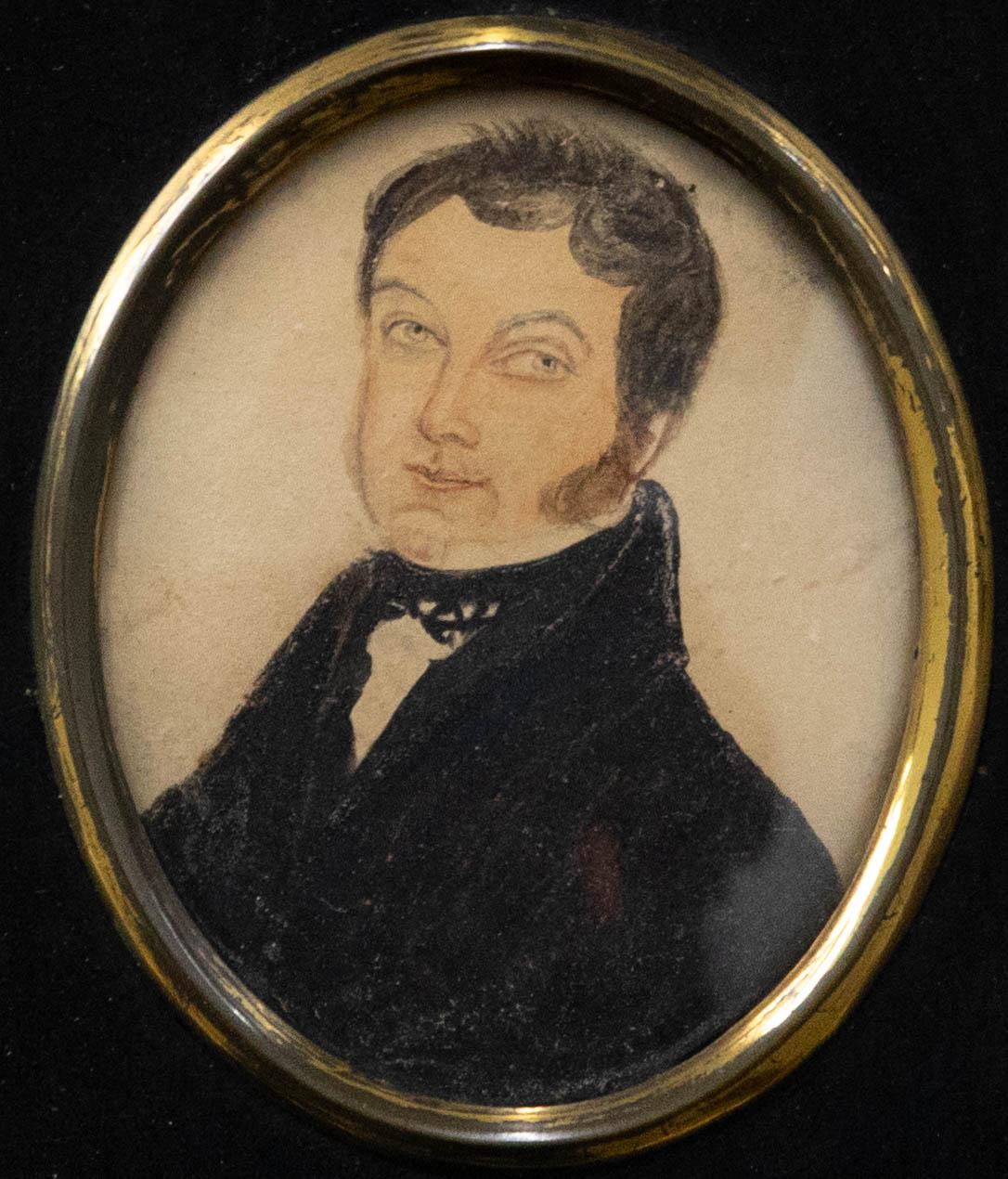 A charming early 19th Century miniature portrait of a kindly looking gentleman in a smart black jacket and wing collar shirt. The portrait is unsigned and presented in a traditional papier mache frame with brass oval inner window and foliate brass