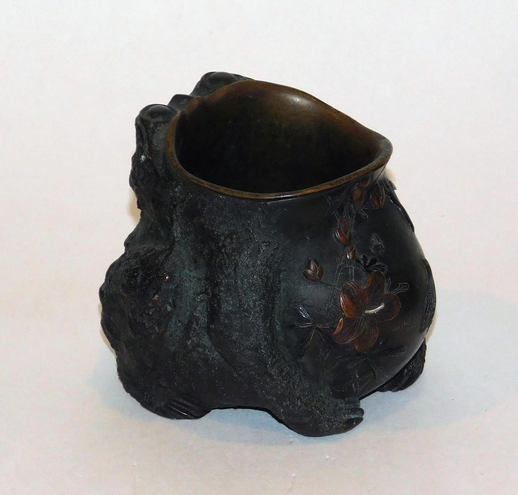 Ces pots fantaisistes en bronze et métal mélangé présentent des crapauds dodus aux yeux d'insecte, des verrues et des 
tous avec des bouches béantes. Ils font d'excellents vases et sont dotés d'un revêtement amovible en métal.
Le ventre des crapauds