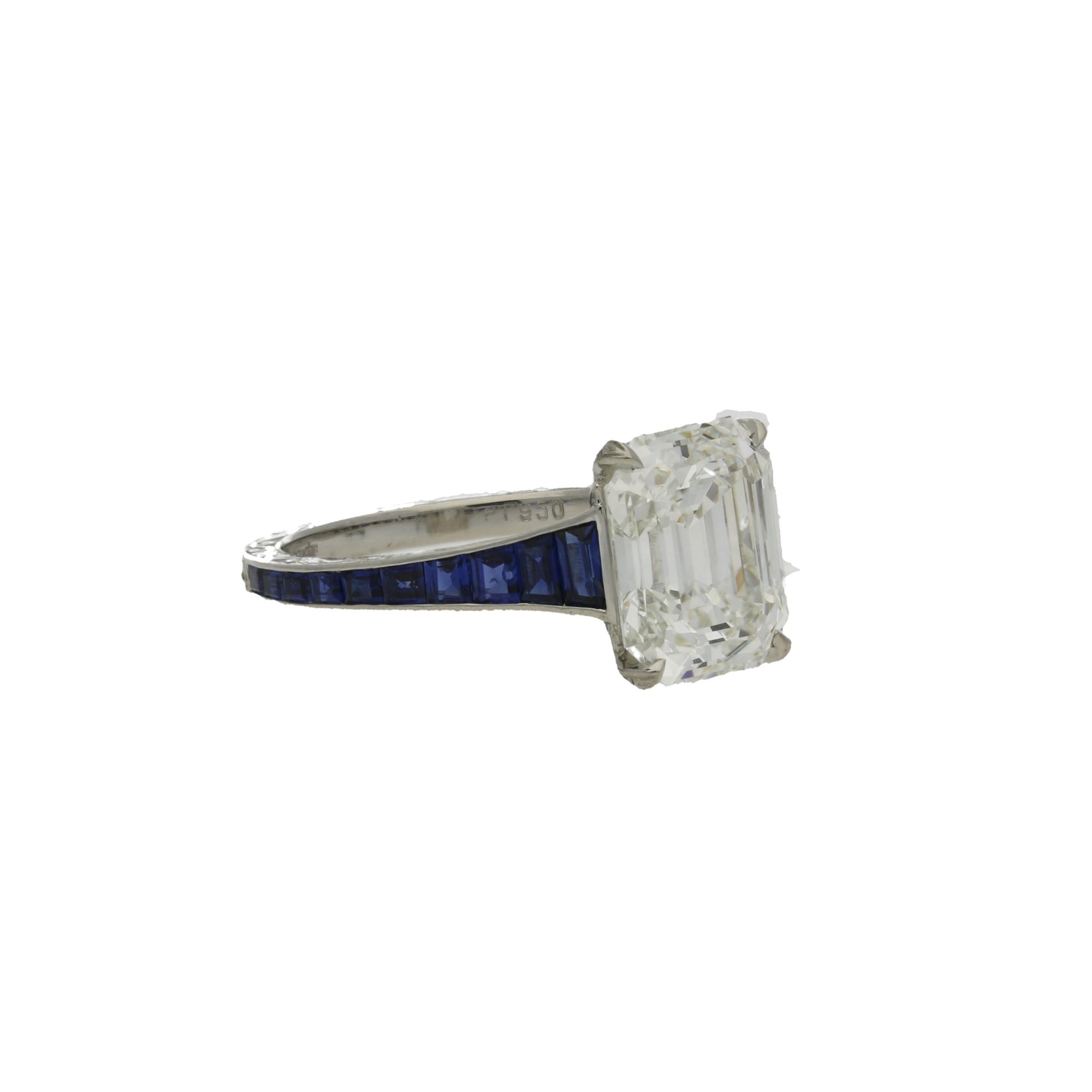 Beautiful Vintage emerald-cut diamond ring by Hancocks, centred on a 3.20 Carats Emerald-cut diamond of H colour and VVS1 clarity, claw set in a hand made platinum mount decorated with ornate hand engraved scroll motifs, the finely tapering band