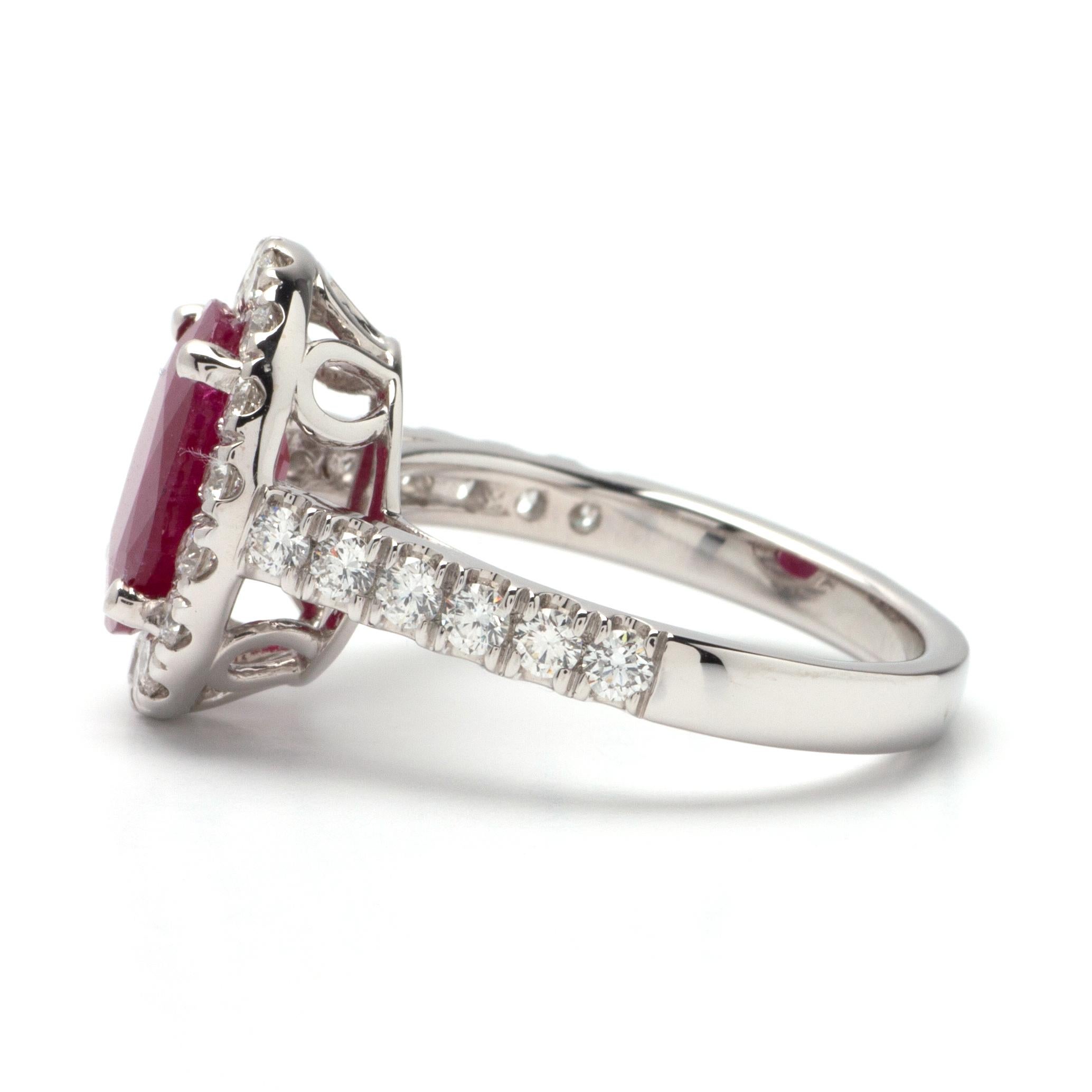 This ring features a halo design of G color, VS1 clarity, and 0.70ct Round side diamonds set in 14K white gold. The center gemstone is a 3.20ct oval ruby measuring 10.51 x 8.08 x 4.37mm. Finger Size 6 3/4.
