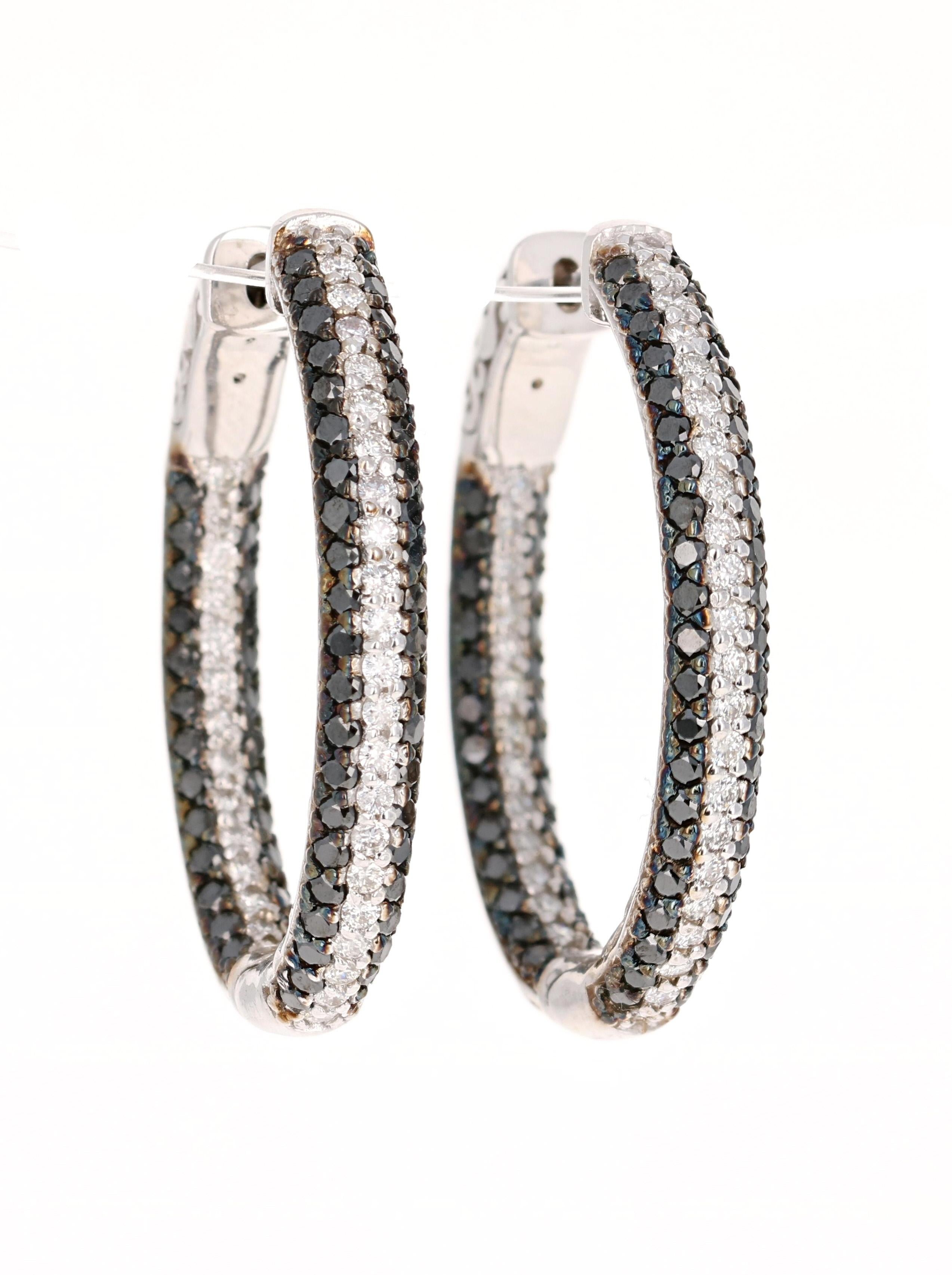 These hoop earrings have 136 Round Cut Black Diamonds that weigh 2.21 Carats and 72 Round Cut White Diamonds that weigh 1.00 Carat. The total carat weight of the earrings are 3.21 Carats. 

Curated in 14 Karat White Gold they weigh approximately