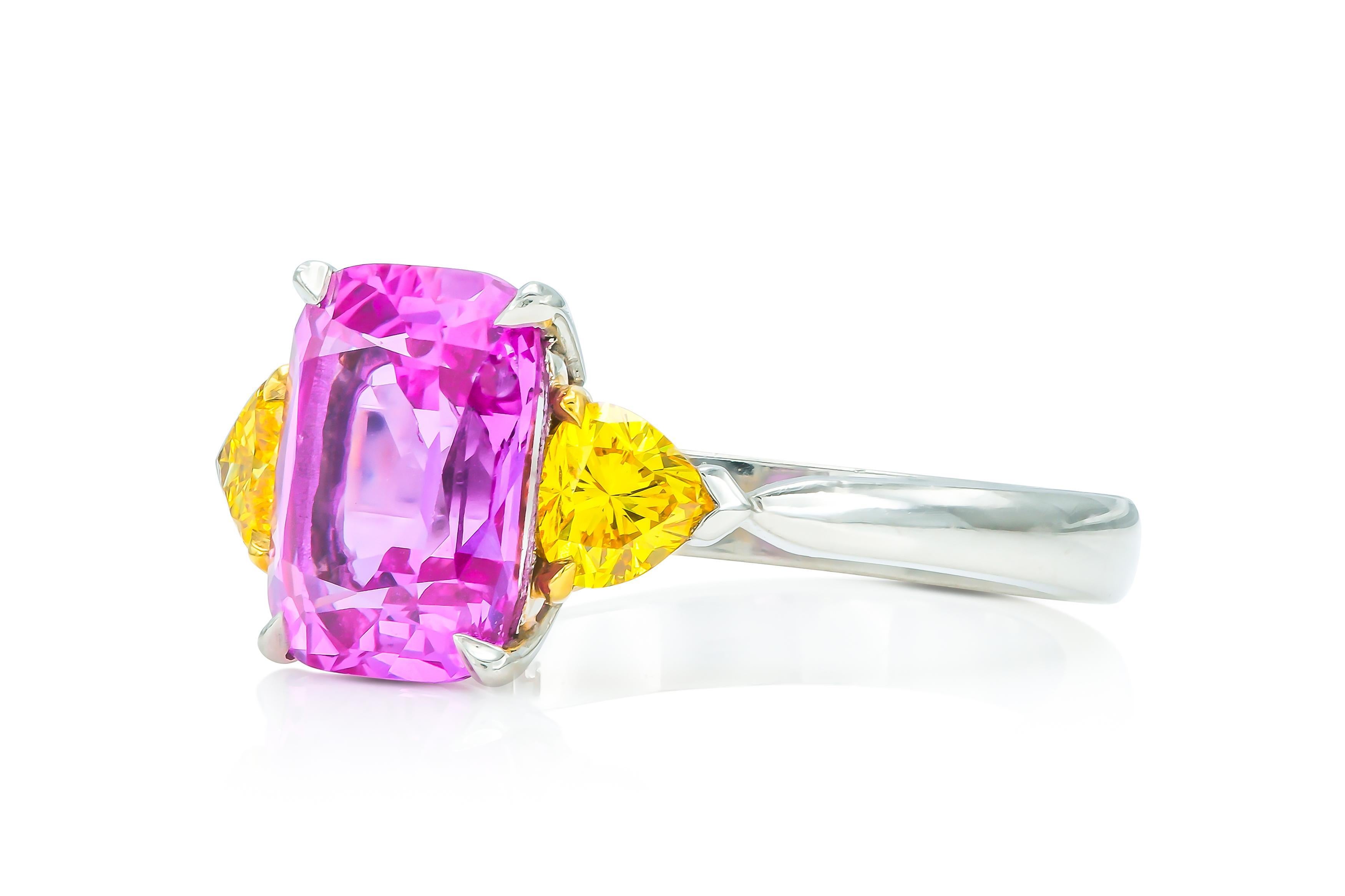 Finement réalisée en platine et en or jaune 18 carats avec un saphir rose à taille coussin certifié AGL, d'origine malgache, pesant 3,21 carats, et deux diamants jaunes à taille trillion pesant au total 0,68 carat.
Taille 6 1/2, redimensionnable