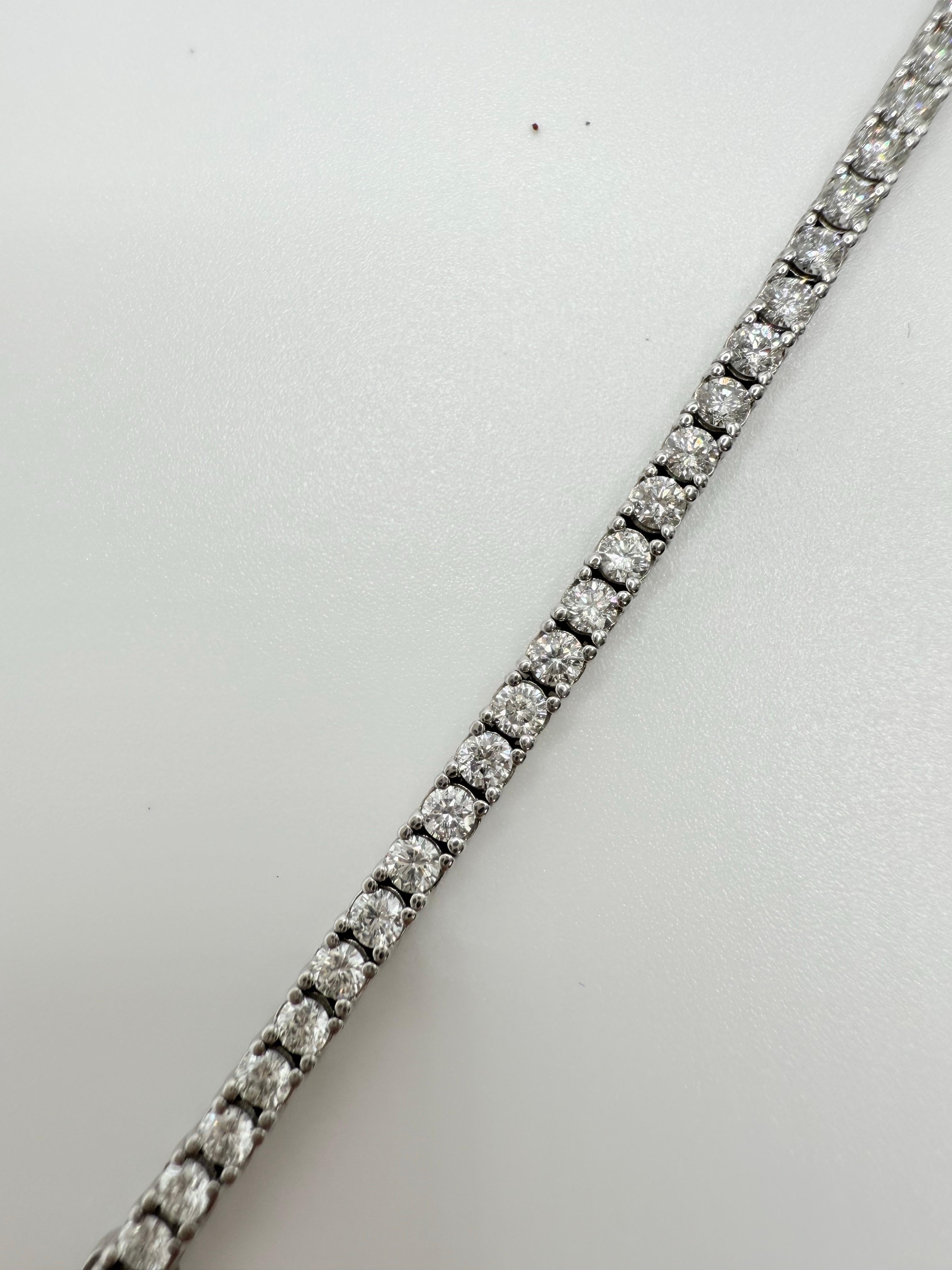 Esta refinada pulsera tenis es el equilibrio perfecto entre elegancia y comodidad. Realizado a mano en oro blanco de 14 quilates y con un peso de 8,80 gramos, está engastado con una línea continua de diamantes redondos talla brillante que suman un