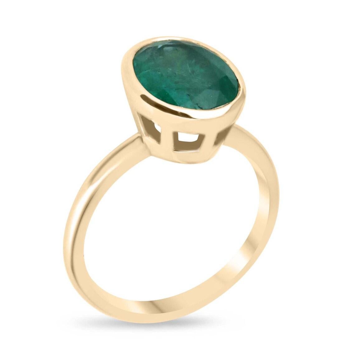 Dieser elegante Solitär-Smaragdring besteht aus einem sambischen Smaragd von 3,21 Karat im Ovalschliff, der durch seinen satten dunkelgrünen Farbton und die halbtransparente Klarheit seine natürliche Schönheit unterstreicht. Der Edelstein ist sicher