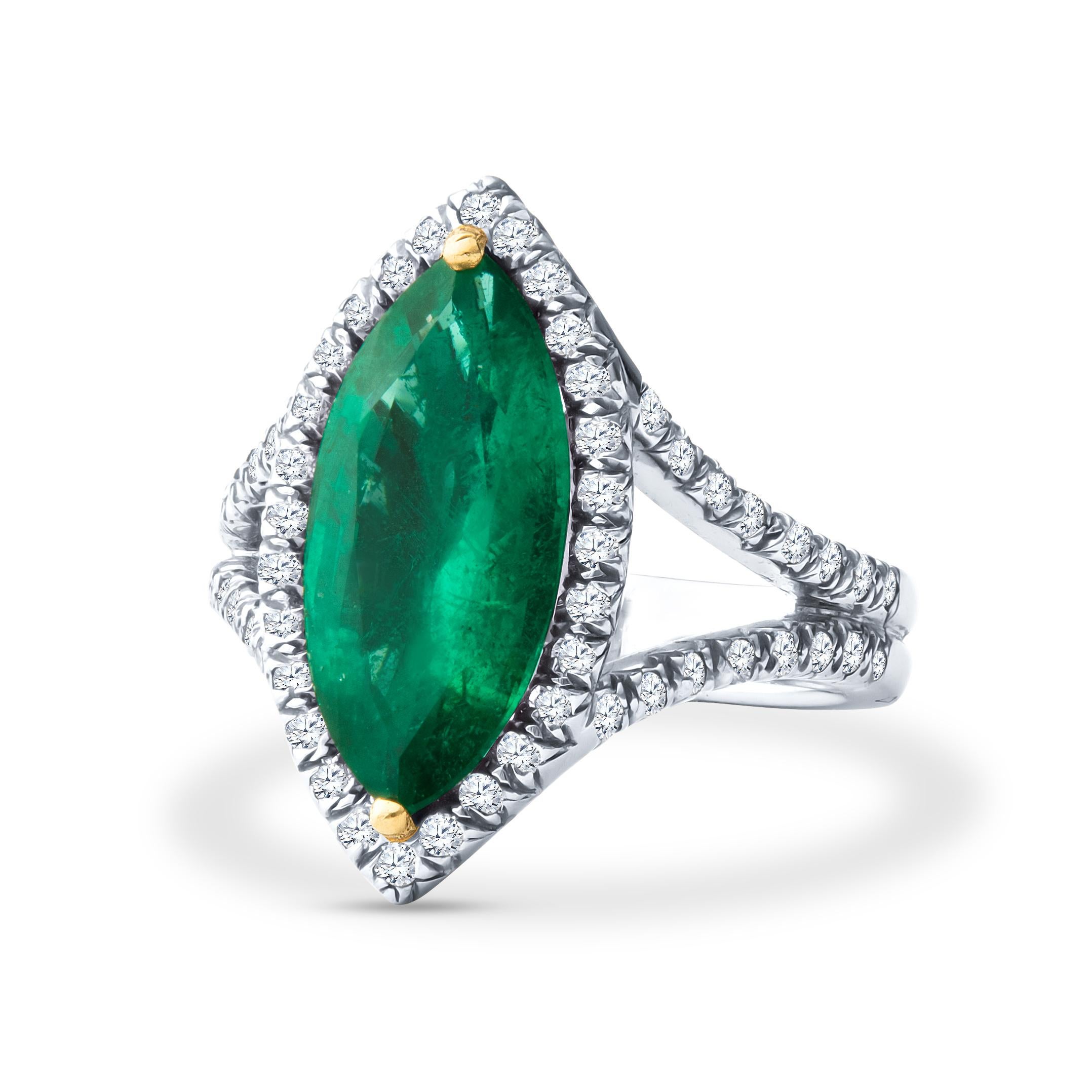 This exquisite ring features a vibrant 6ctw marquise shaped emerald surrounded by 1.07ctw halo of round diamonds forming the halo and split shank band. The ring itself is made of platinum and is currently a size 6.5.  It can be resized upon request.
