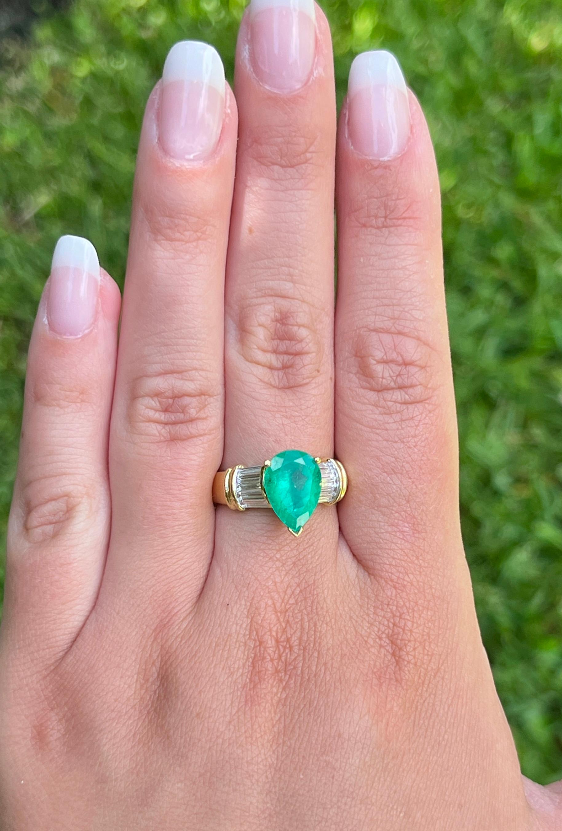 This ring presents a sophisticated blend of elegance and luxury, showcasing a 3.22 carat pear-shaped natural Colombian emerald center stone. Adorned with 0.66 CTTW in baguette-cut diamond side stones. The center stone is set in a 3-prong setting
