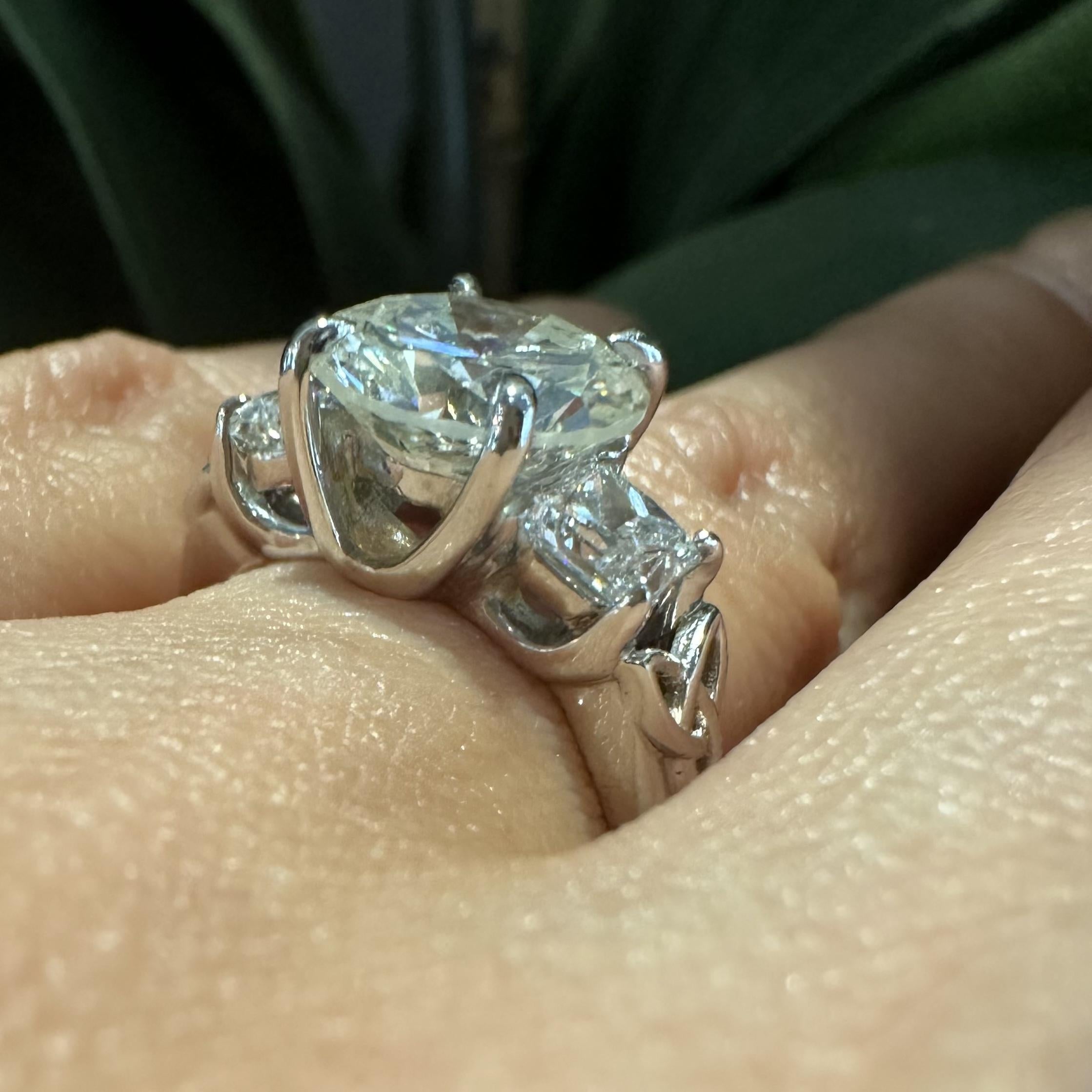 Beautiful engagement ring featuring a round center stone with 2 side princess cut stones.