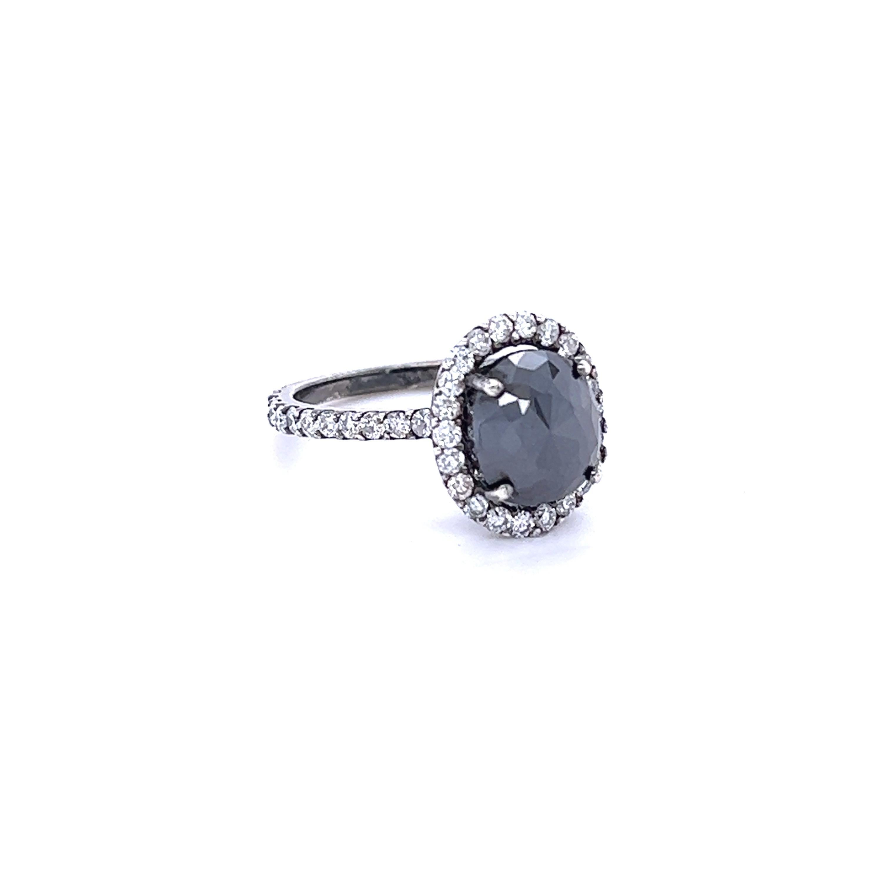 Oval Cut Black Diamond that weighs 2.28 Carats and is surrounded by 46 Round Cut Diamonds that weigh 0.95 Carats. The total carat weight of the ring is 3.23 Carats. The black diamond measures at 9 mm x 8 mm.

Crafted in 14 Karat White Gold that has