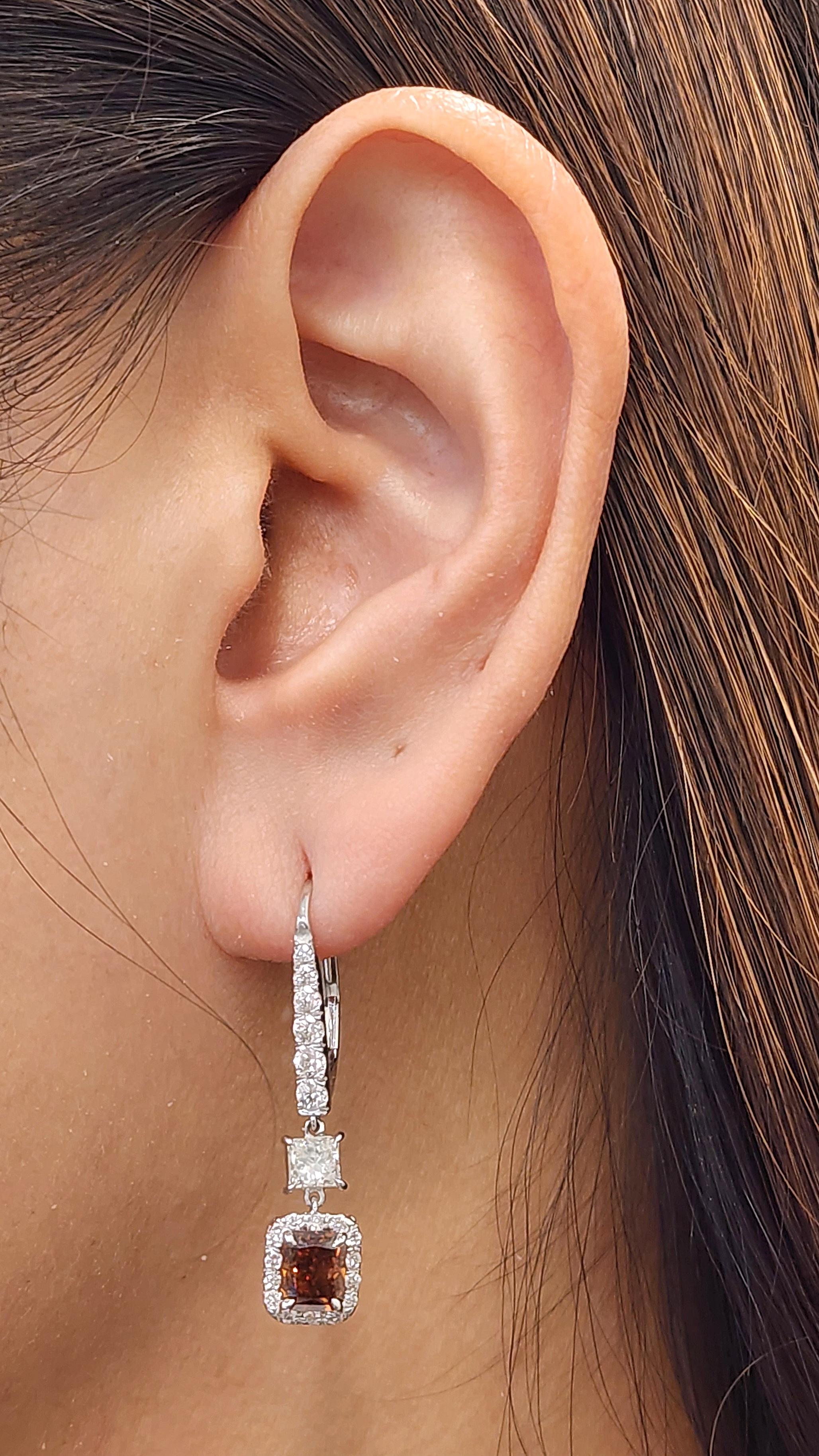 These stunning natural fancy deep orange-brown diamond earrings feature 2 natural GIA diamonds weighing 2.02 ct and 50 diamonds weighing 1.21 ct set in 18k white gold.  The fancy diamonds showcase SI2/I1 in clarity. A beautiful set to add to any