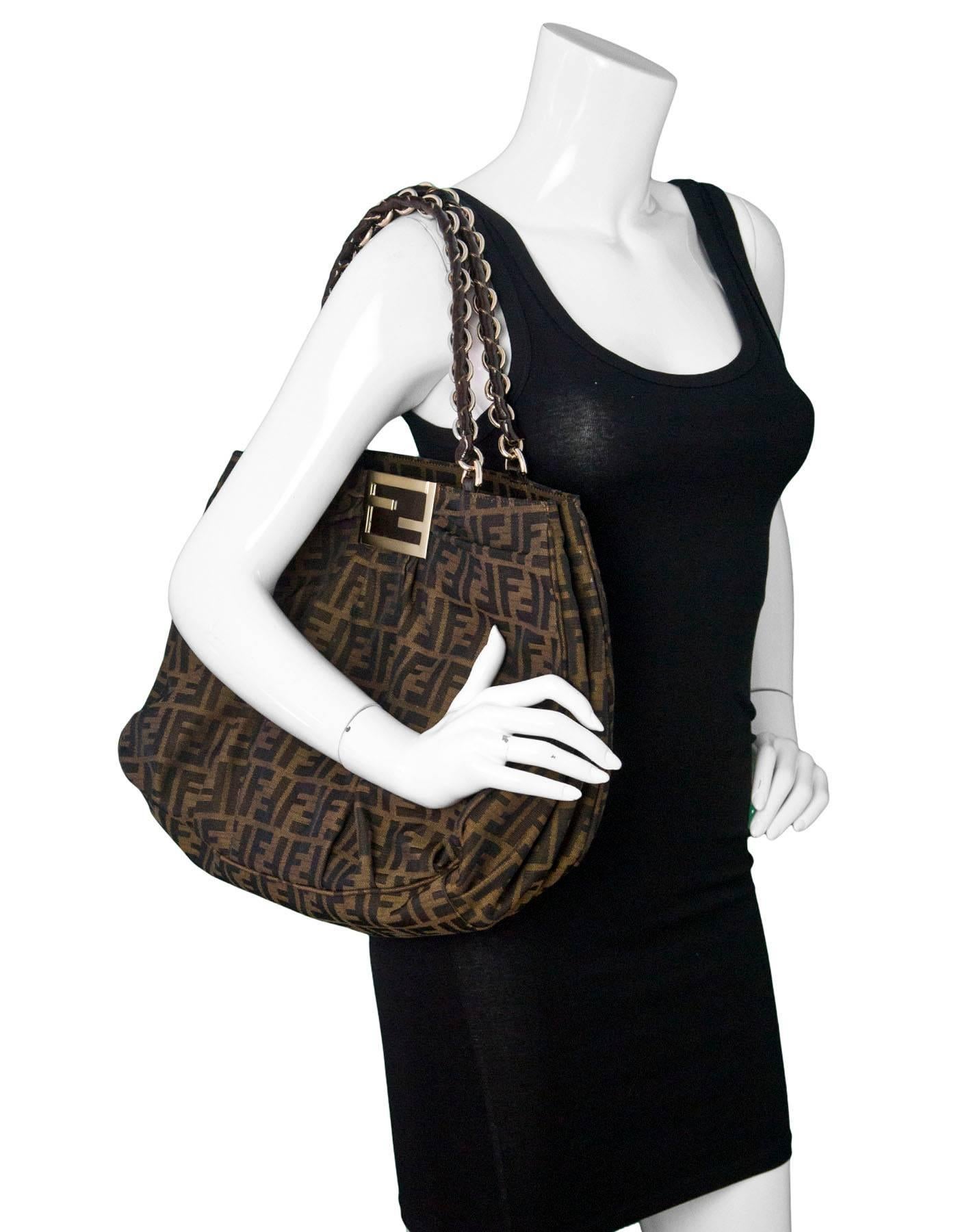 Fendi Tobacco Brown Zucca Borsa Mia Tote
Features woven straps

Made In: Italy 
Color: Brown
Hardware: Goldtone
Materials: Canvas, patent leather, metal
Lining: Tan textile
Closure/opening: Open top
Exterior Pockets: None
Interior Pockets: Center