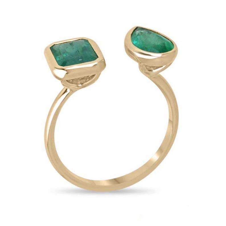 Dieser exquisite Ring von Toi et Moi besteht aus einem bezaubernden natürlichen Smaragd im Smaragdschliff und einem auffälligen Smaragd im Birnenschliff, die beide aus den berühmten Minen in Sambia stammen. Diese üppigen grünen Edelsteine mit