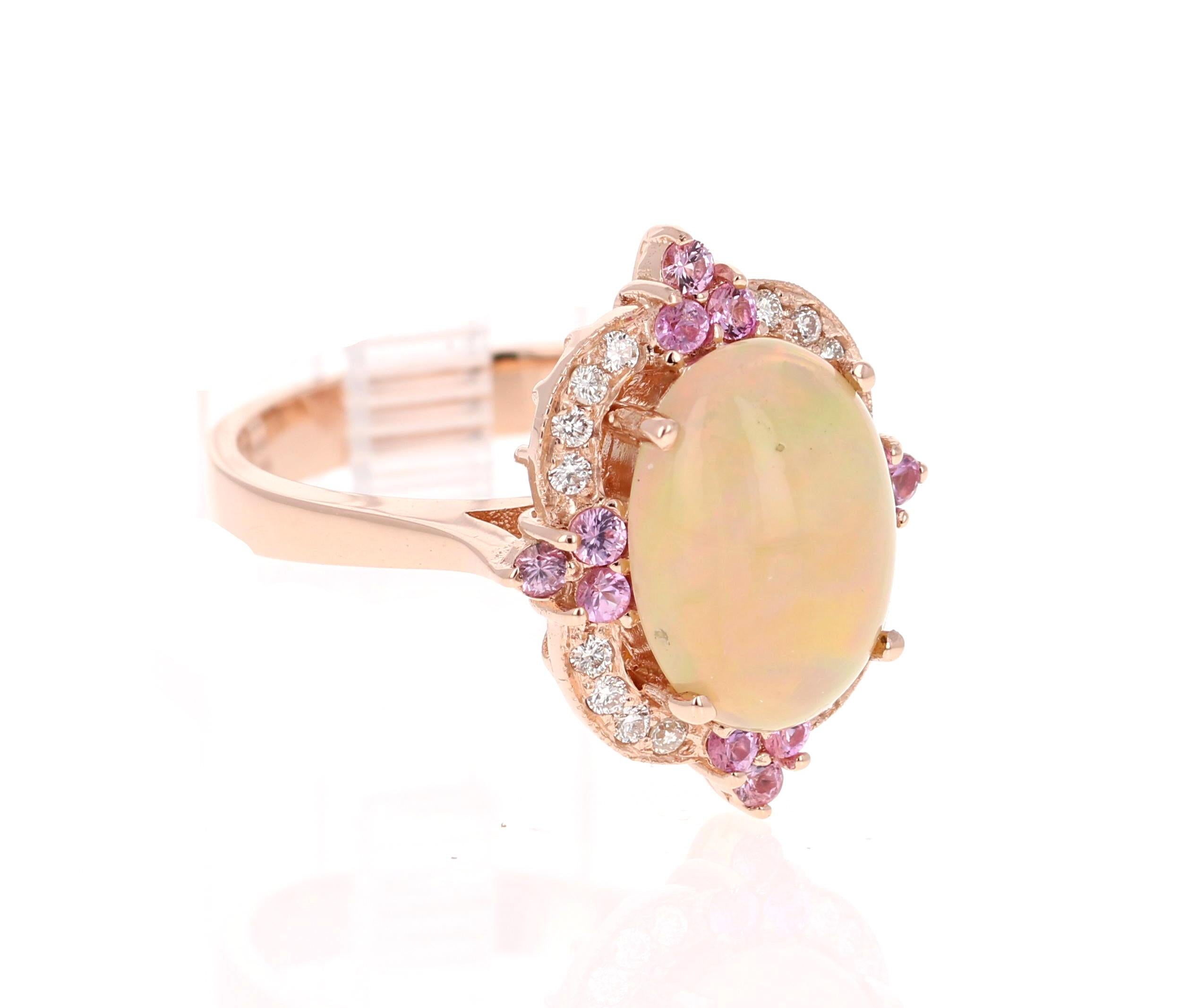 The Oval Cut Opal in this ring weighs 2.67 Carats and the measurements of the Opal are 8 mm x 12 mm. The Opal is surrounded by 12 Pink Sapphires that weigh 0.37 carats and also 16 Round Cut Diamonds that weigh 0.20 Carats. (Clarity: VS, Color: H)