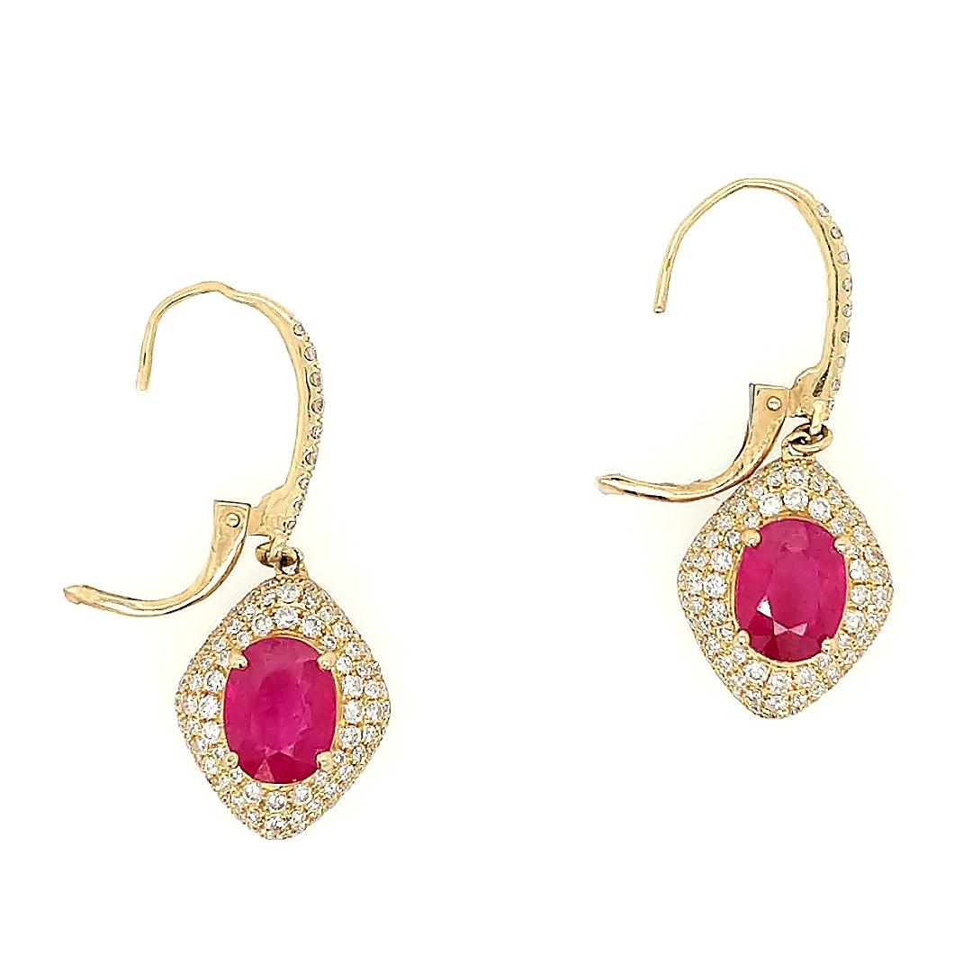 These ruby and diamond earrings are crafted in 14k yellow gold featuring (2) oval rubies weighing 3.24 carats. The rubies are surrounded by 182 diamonds weighing approximately 1.82cttw with a color of H/I and a clarity of SI1. 