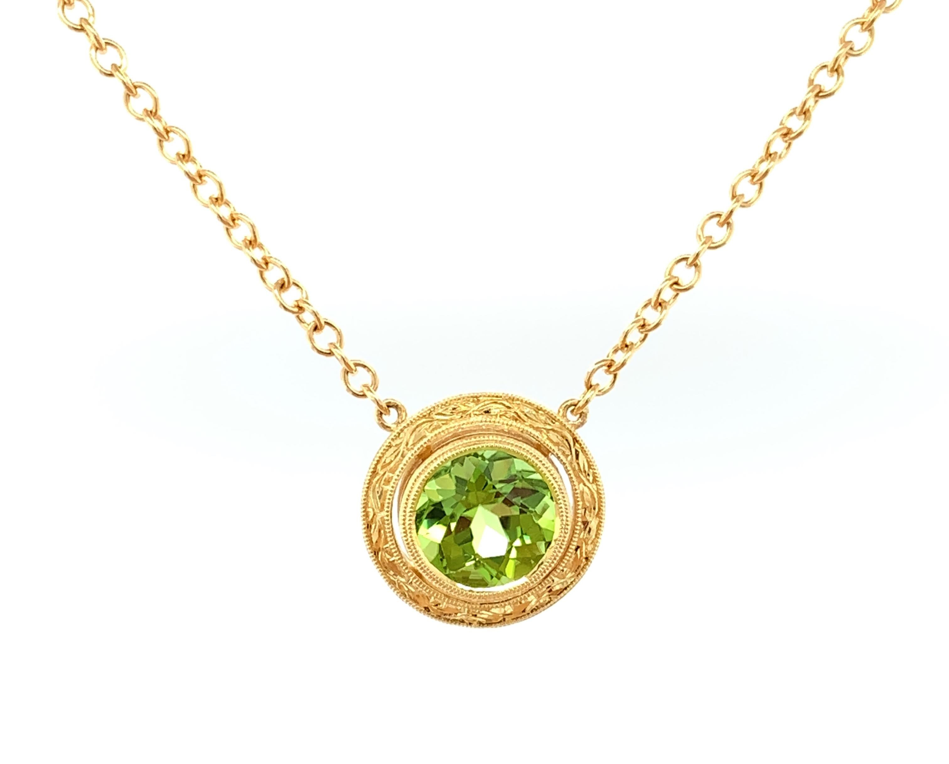 This brilliant, lime-colored peridot sparkles brightly because it is so beautifully cut. It is large for a round shaped peridot, making it a striking center stone for a necklace. It is set in an 18k yellow gold bezel that has been intricately
