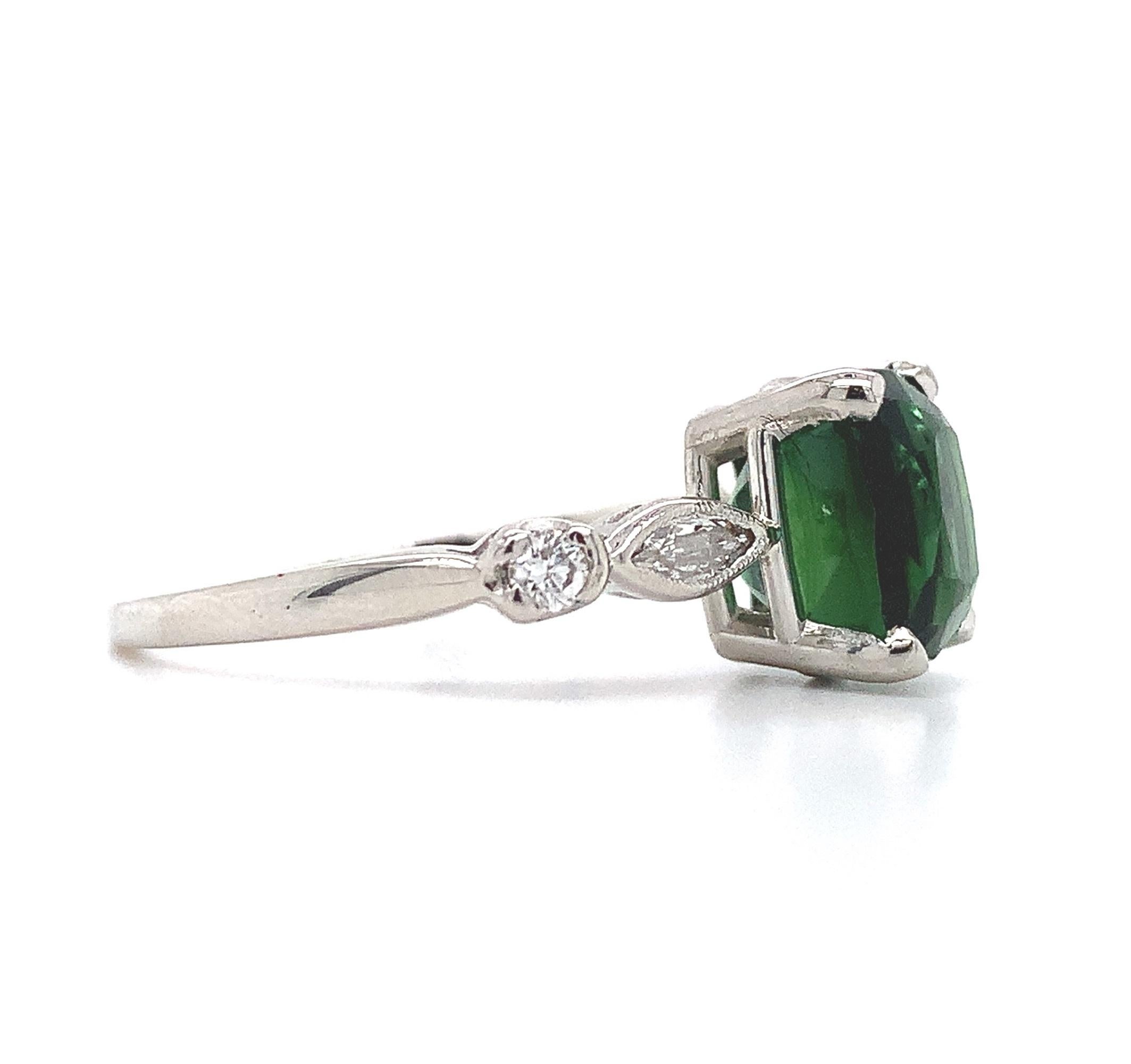  Platinum tourmaline and diamond ring featuring a rectangular cushion cut tourmaline weighing 3.24 carats. The tourmaline has chrome green color and fine clarity. It measures about 8.5mm x 7mm. The tourmaline is accented by 2 marquise diamonds and 2