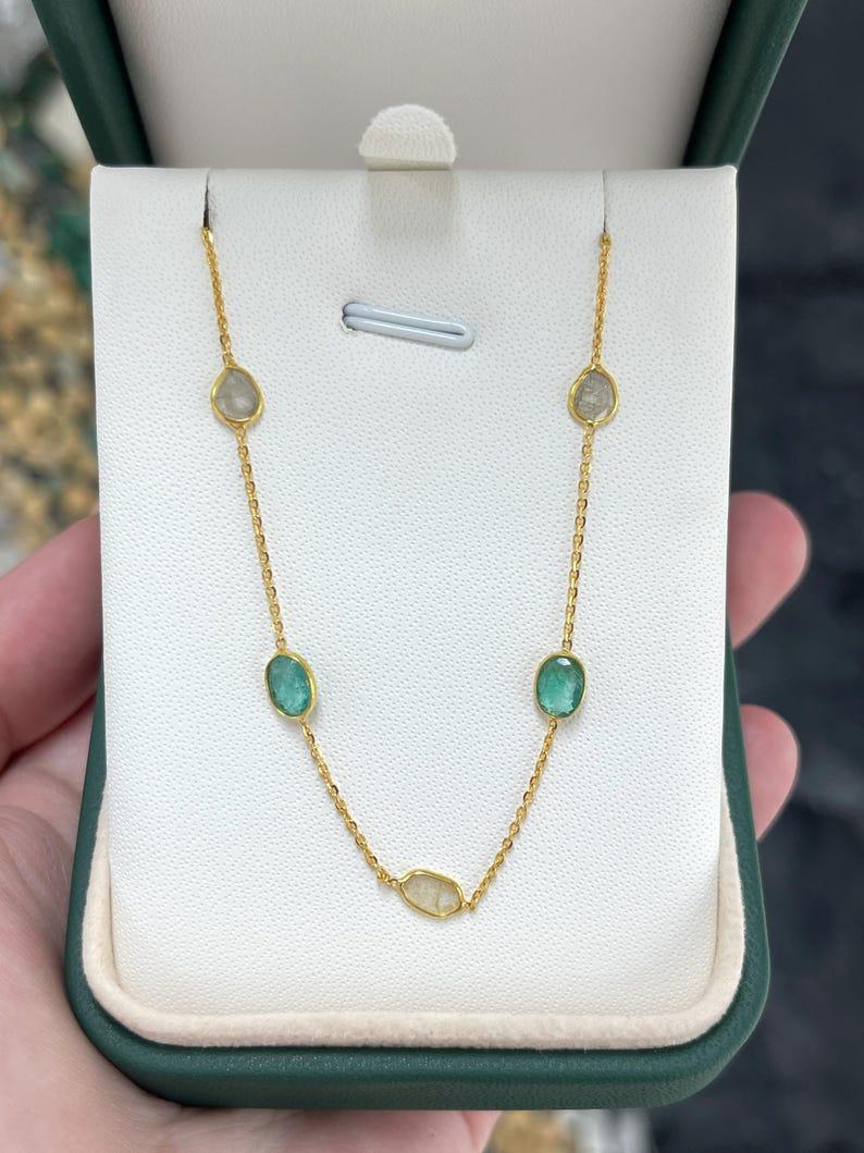 Ti presentiamo la nostra collana mozzafiato di smeraldi e diamanti di Yard, un capolavoro di eleganza e rarità. Questa collana è caratterizzata da squisiti smeraldi naturali ovali, ciascuno incastonato singolarmente per mostrare la loro vibrante