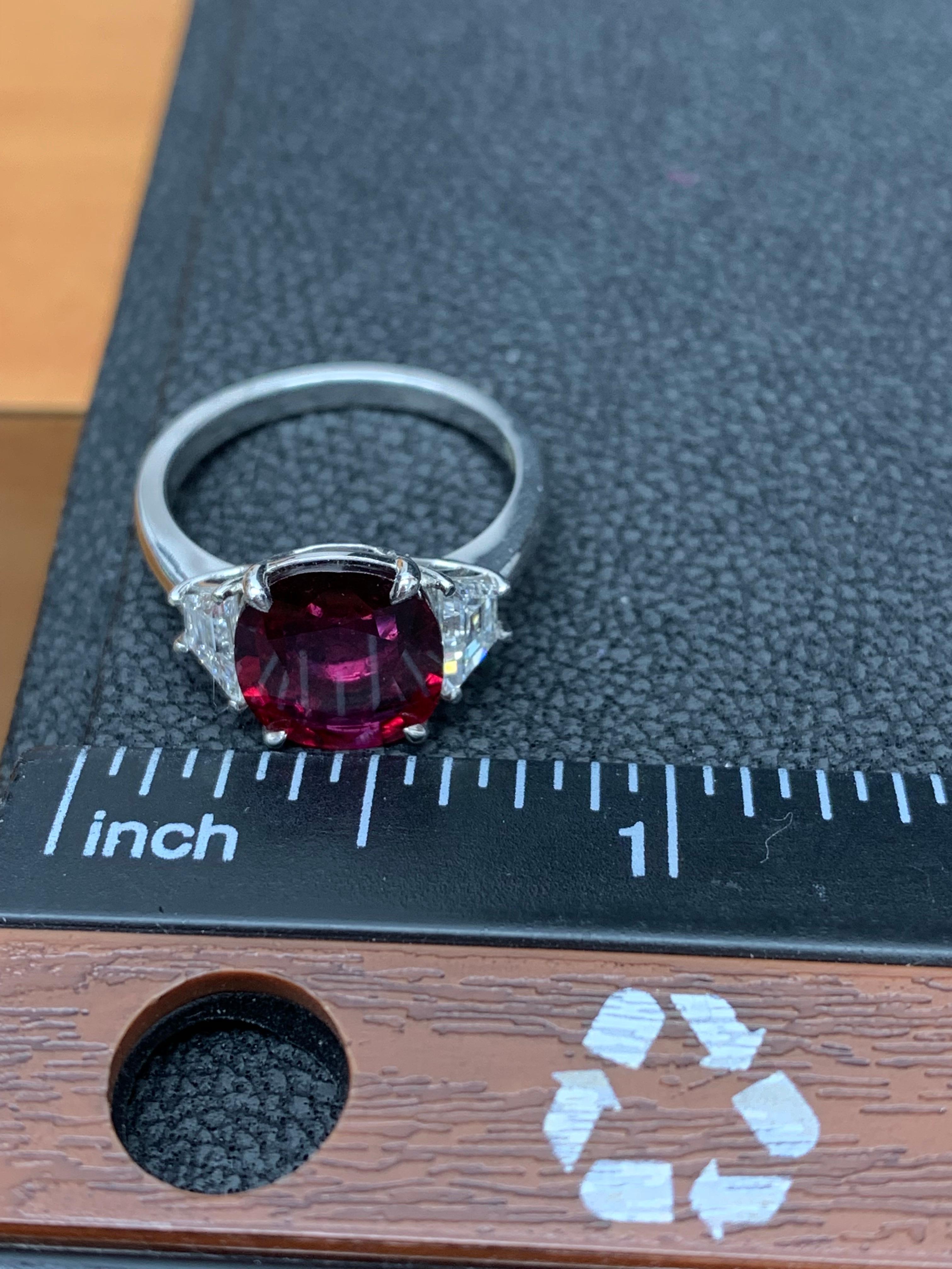 Features a gorgeous ruby and diamond one-of-kind ring. Flanking the ruby are 2 step cut trapezoids diamonds weighing 0.62 carats total. Set in a platinum composition. Size 6.5 (sizable upon request).