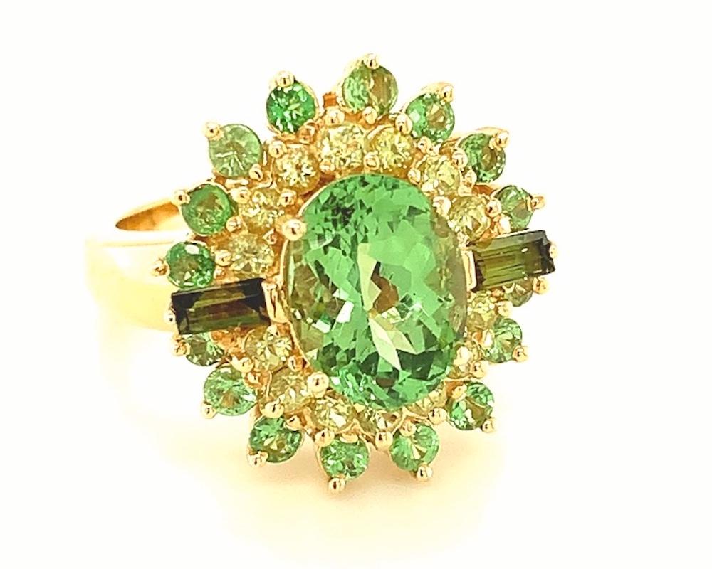 This fun ring features a sparkling green tsavorite garnet surrounded by a bright cocktail of beautiful colored stones. The center gem is the rare variety of green garnet named after Tsavo Park in Kenya, and is accented by a halo of round peridots,