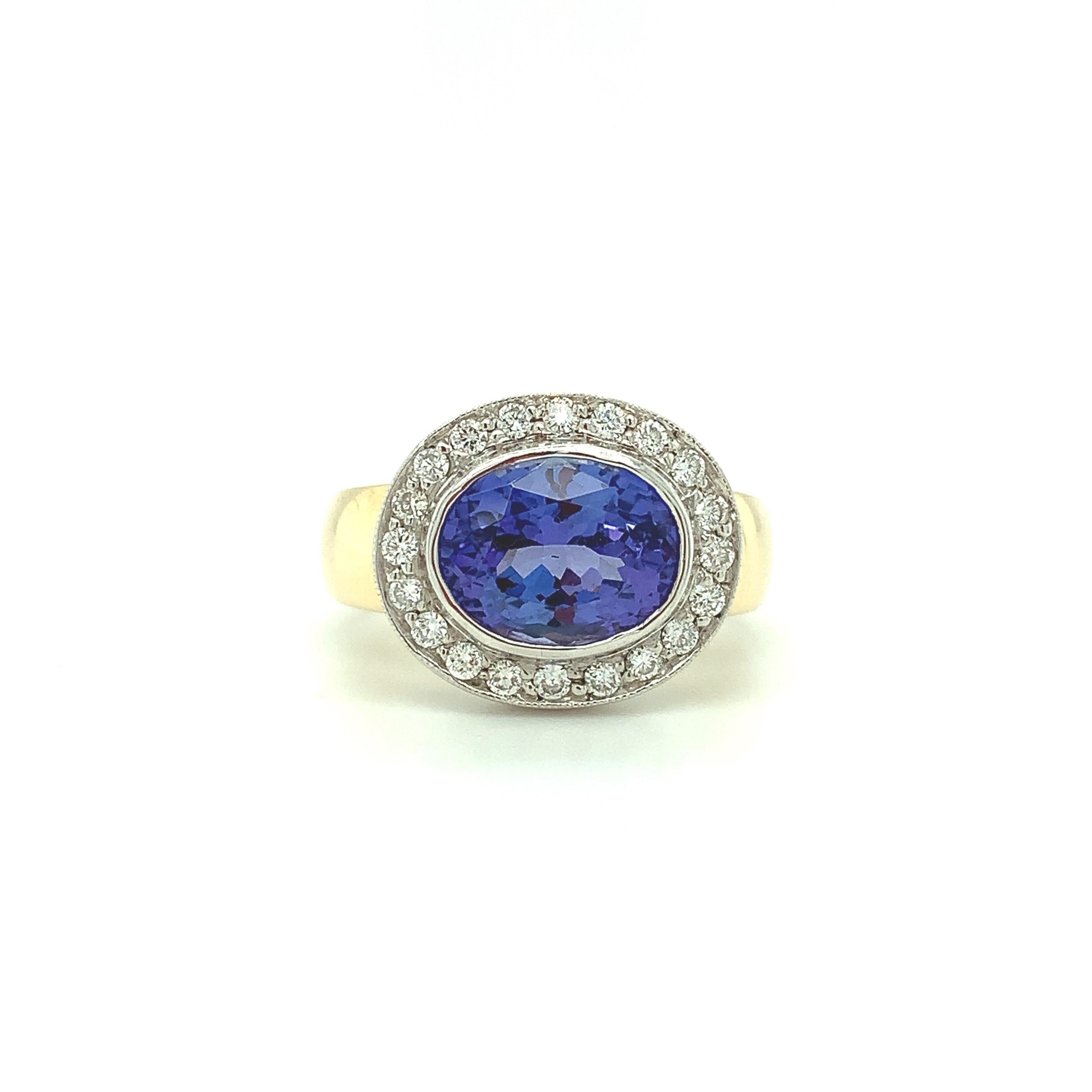 This vivid periwinkle blue tanzanite and diamond halo ring is a dazzling treat for the eyes! The tanzanite is set in striking 18k white gold and surrounded by a sparkling halo of pave set brilliant white diamonds. The band is made of 18k yellow