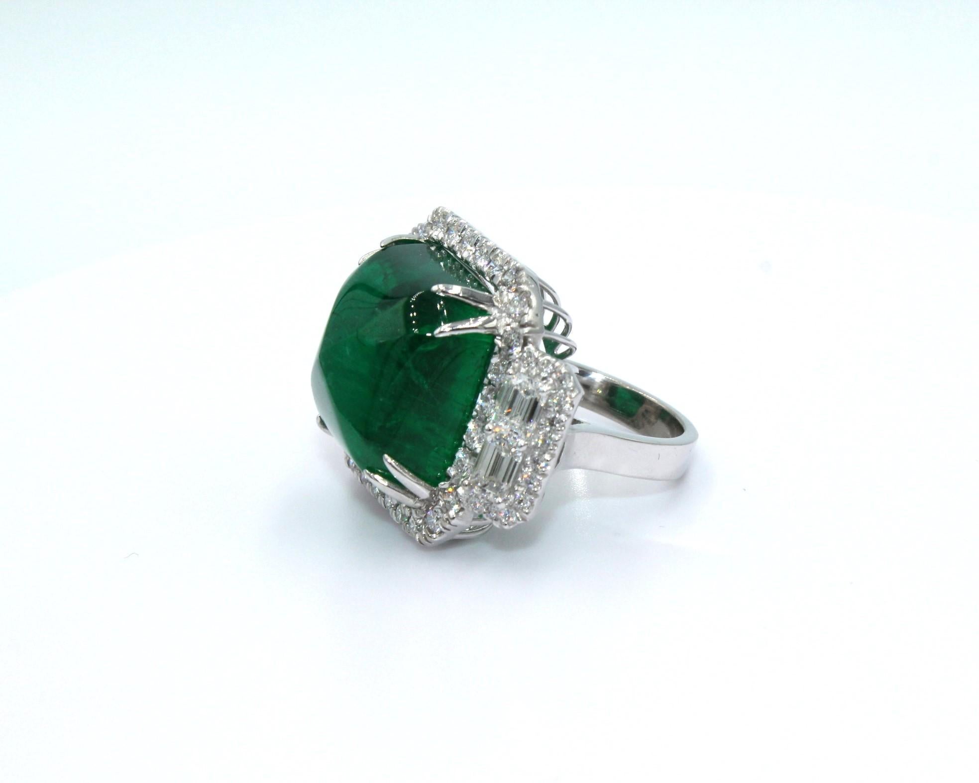 32.62 carats Sugarloaf Cabochon Zambian Emerald with framing 53 round diamonds and 4 emerald-cut diamonds on both sides, totaling a diamond weight of 3.11 carats. 

This piece will highlight your elegance and uniqueness. 

*Lab Certificate is