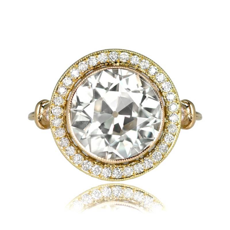 A captivating yellow gold ring with a vibrant 3.26-carat old European cut diamond at its center. Encircling the main stone is a halo of pave-set old European cut diamonds. This exquisite ring is hand-crafted in 18k yellow gold and features an