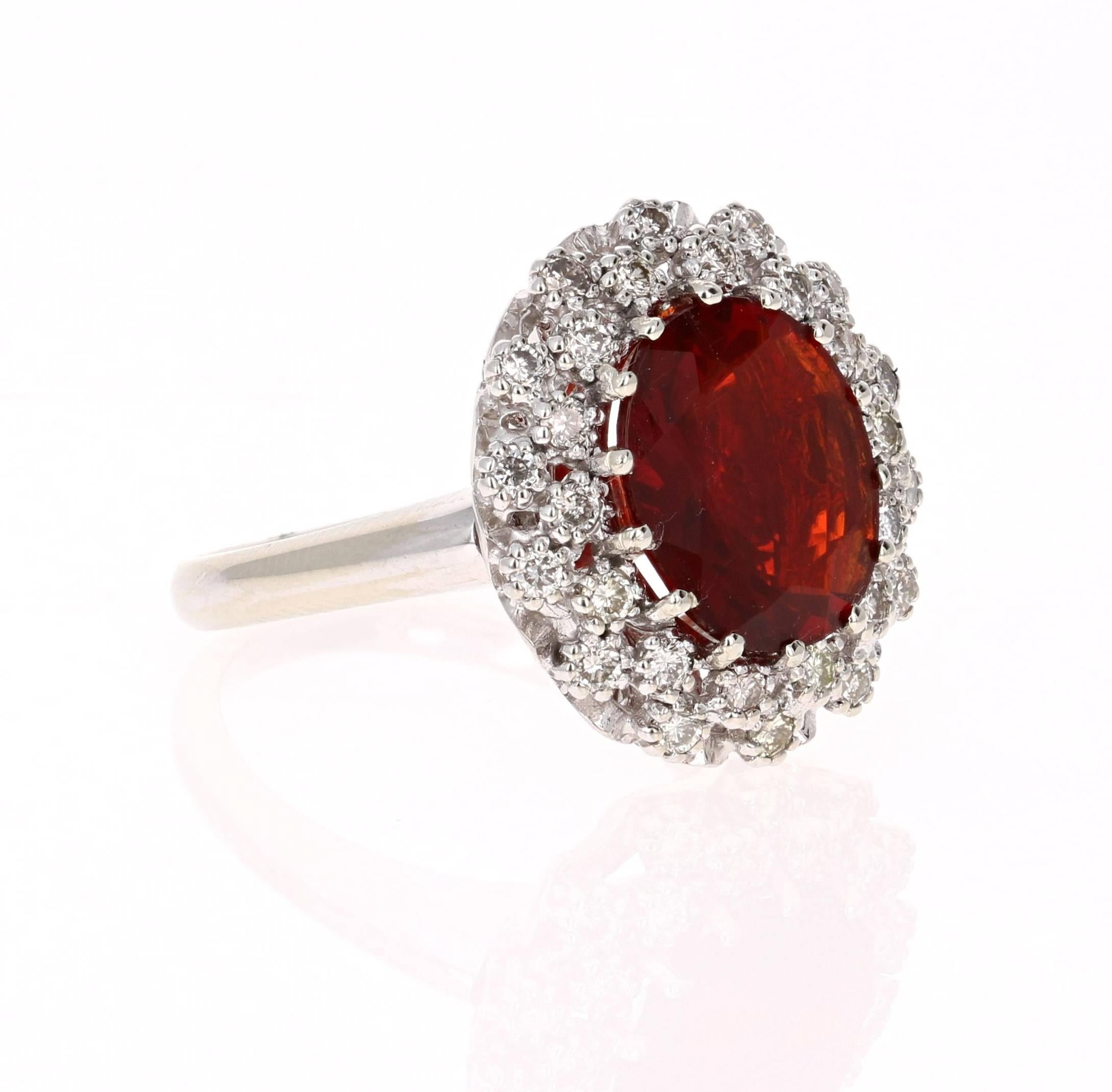 This gorgeous cocktail ring has a scintillating Oval Cut Fire Opal that weighs 2.64 carats and 28 Round Cut Diamonds that weigh 0.63 carats. The clarity and color of the diamonds are VS2-H.  The total carat weight of the ring is 3.27 carats. 

It is