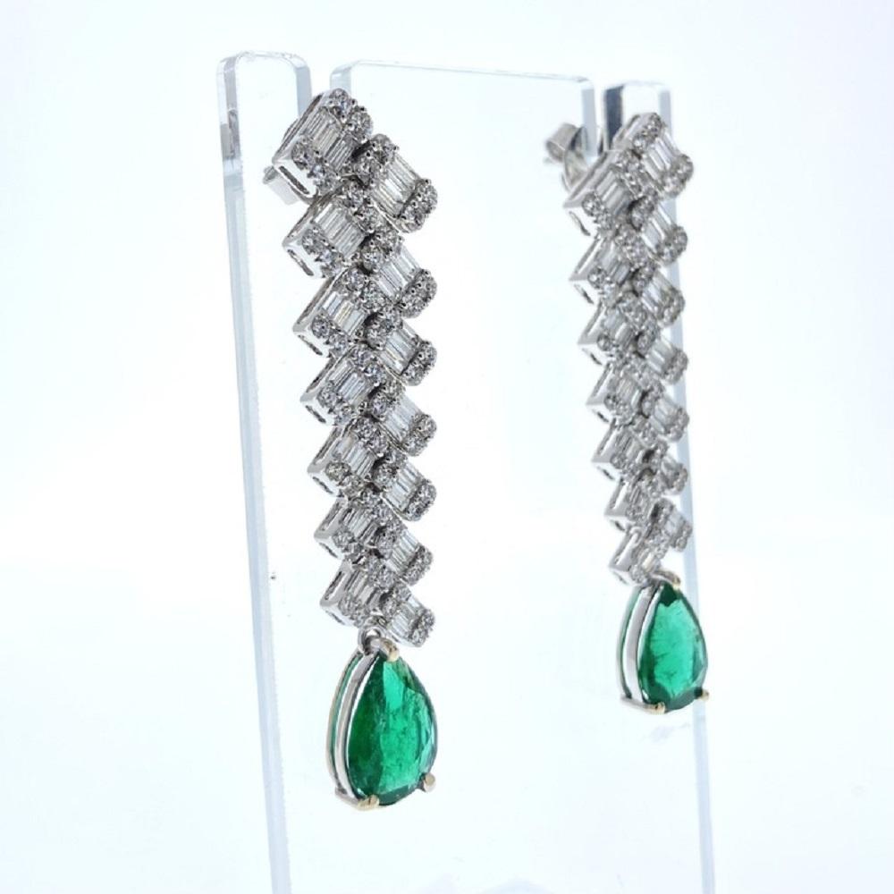 ein Paar modische Ohrringe mit einem birnenförmigen Smaragd als Hauptstein, mit einem Gewicht von 3,27 Karat und einer grünen Farbe. Außerdem dienen 328 Diamanten als Nebensteine. Die Form der Diamanten ist nicht angegeben, aber ihr