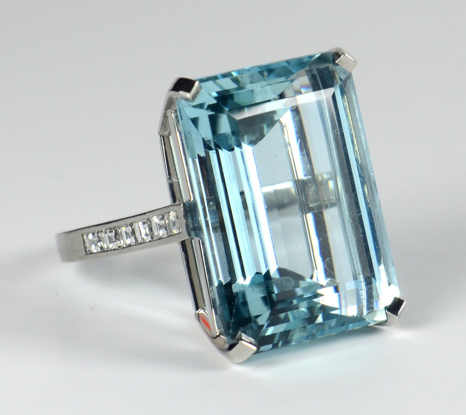 An elegant aquamarine ring with channel-set carré cut diamond shoulders mounted in platinum. The aquamarine is a clean stone with a fine clear blue colour.

The aquamarine measures 22.4 x 17 x 10.8mm and is estimated to weigh 32.70 carats. 
There