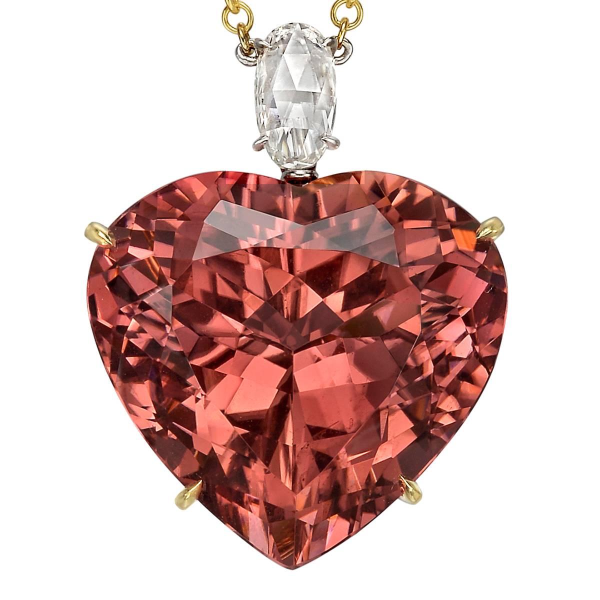 Pendant necklace, showcasing a large heart-shaped pink tourmaline weighing 32.73 carats (measuring approximately 21 x 20mm) with an oval rose-cut diamond surmount weighing 0.90 carats, in 18k yellow gold, the pendant suspended from a 16