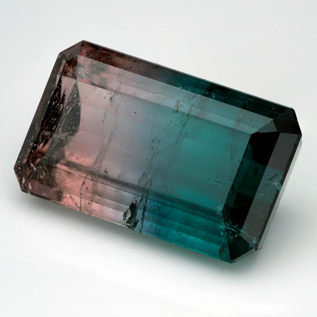 This striking 32.75-carat Watermelon Tourmaline showcases a rare and highly desirable bi-color transition, blending delicate blush pink into rich teal blue with natural clarity and brilliance. Expertly faceted into a beautiful emerald cut, this