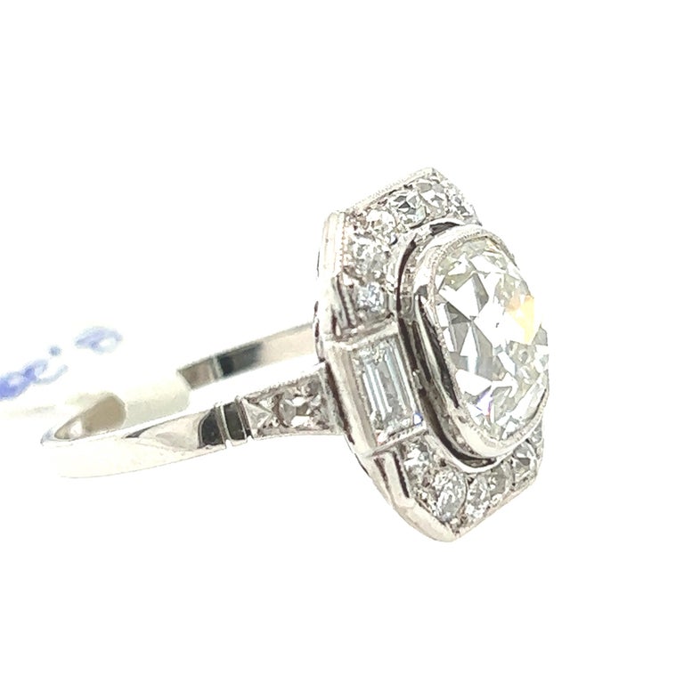 For sale is a stunning antique cushion cut diamond, weighing 3.28 carats, set in a platinum ring with a beautiful art deco style. The center stone is an exquisite example of the cushion cut, which was a popular choice during the early 20th century.