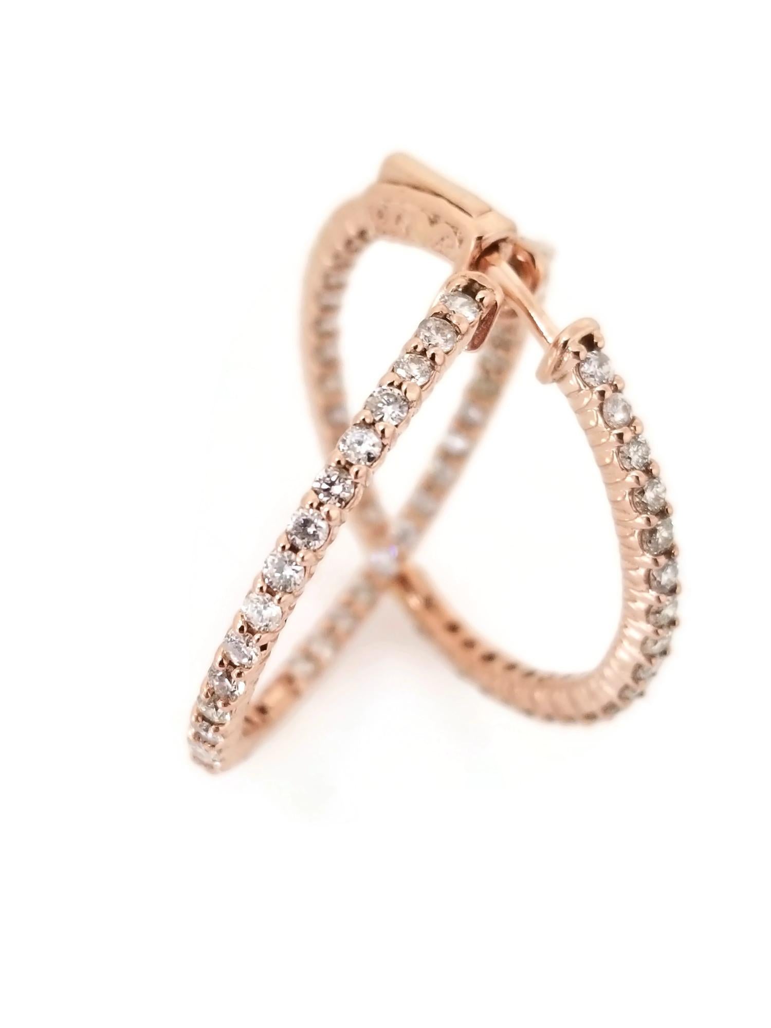 Beautiful pair of diamond inside out hoop earrings in 14K Rose gold. Secures with snap closure for wear. Average Color H, Clarity VS-SI, Measures 1.25 inch in diameter. 