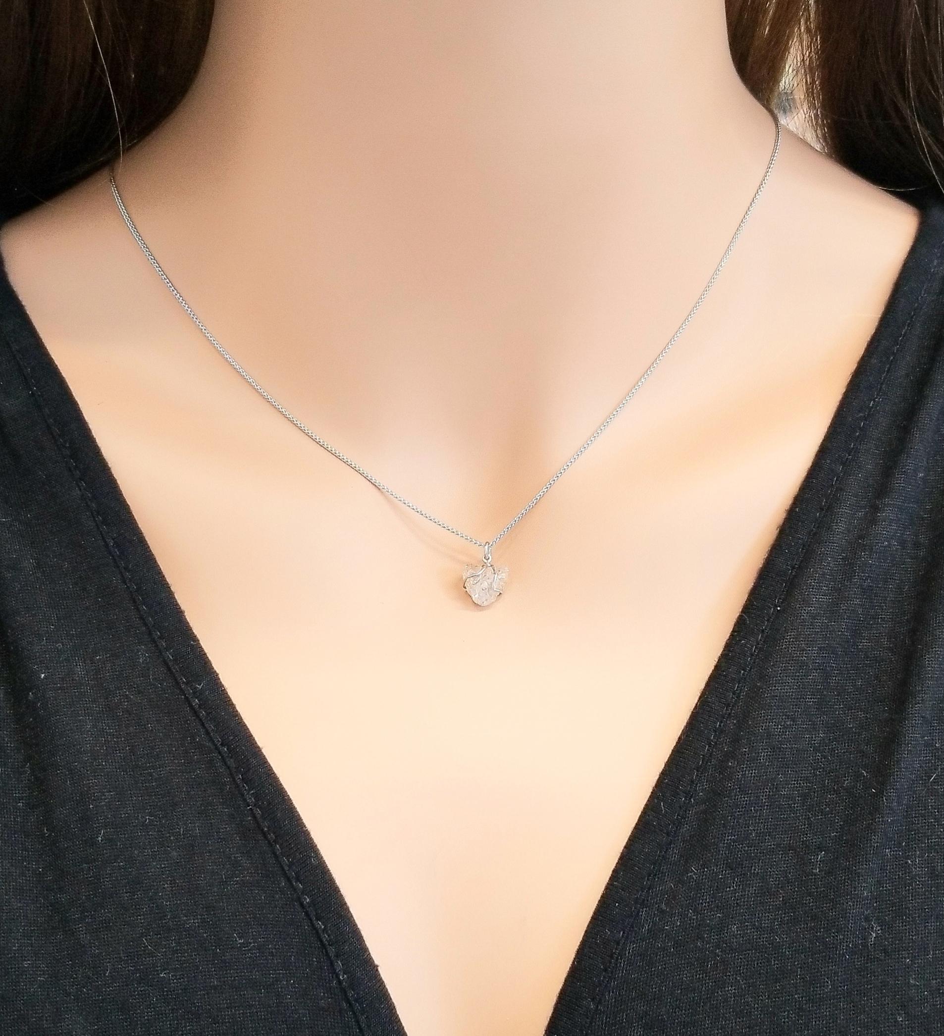 This contemporary diamond solitaire pendant necklace is finely crafted in brightly polished 14 karat white gold and features a stunning 3.28 carat rough diamond beautifully set on a slim bail. This solitaire diamond displays natural growth patterns