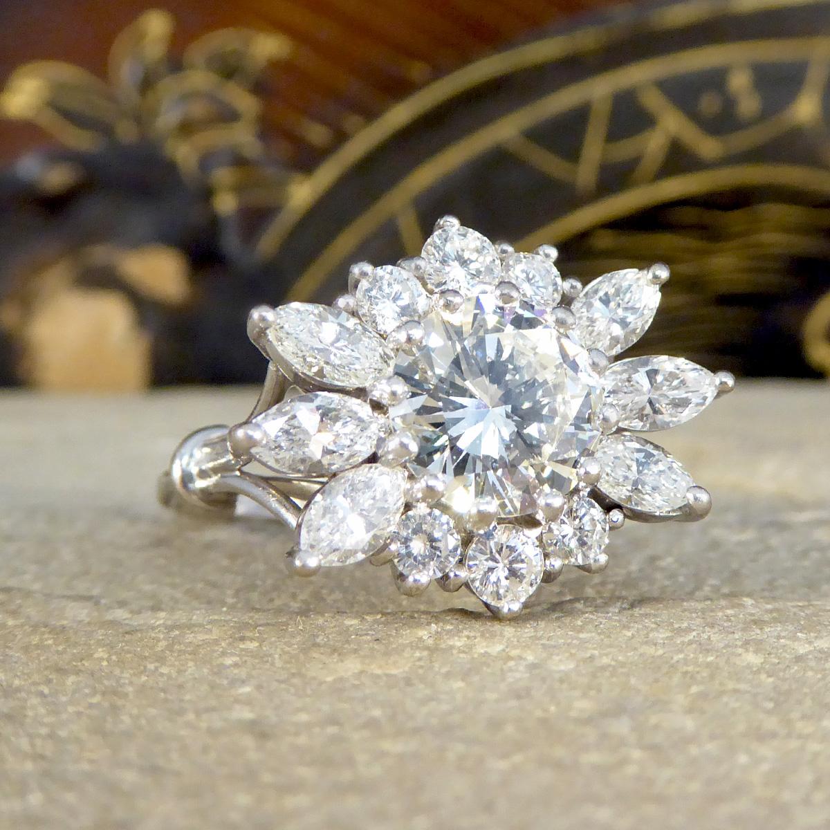 This exquisite 3.28ct Diamond flower burst cluster ring is a magnificent display of craftsmanship and elegance, set in luxurious 18ct white gold. At the centre of this breathtaking piece lies a captivating 1.98ct brilliant cut diamond, chosen for