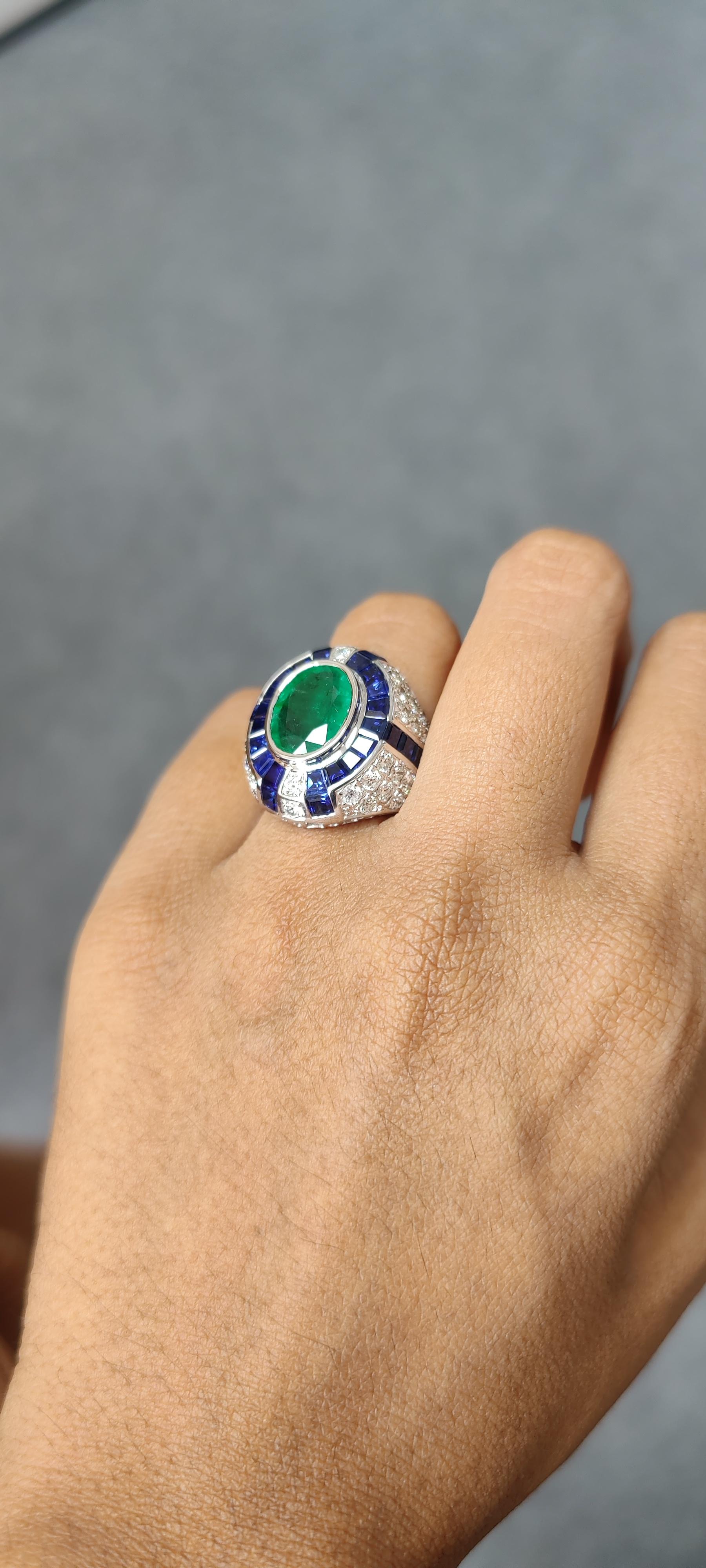 Oval Cut 3.29 Carat Art Deco Emerald Ring studded with Blue Sapphires & Diamonds For Sale