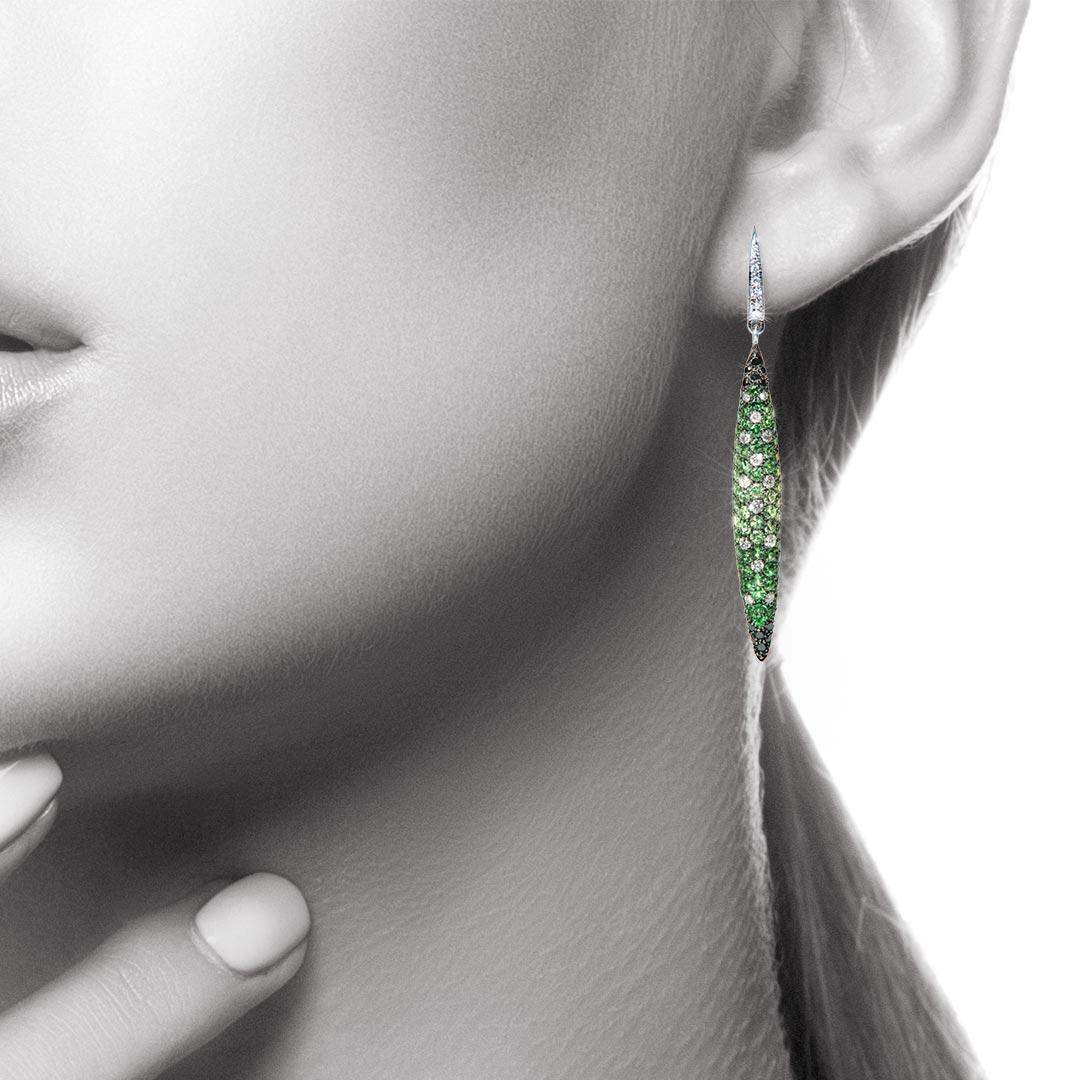 A spectacular pair of Drop Earrings with a real Art Deco feel. The long marquise shapes are sparkling with 130 Green Tsavorite Garnets (total weight of 3.29 carats), 32 Black Diamonds (total weight of 0.45 carat) and 38 White Diamonds (total weight