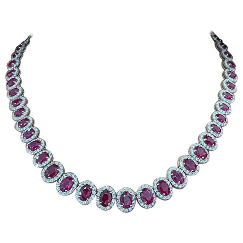 This ruby & diamond necklace features 55 natural oval-shaped rubies weighing 24.11 cts. The rubies are surrounded by 723 natural round diamonds weighing 9.26cts set in 18k white gold. The diamonds are graded E-F in color and VS1-VS2 in clarity. The