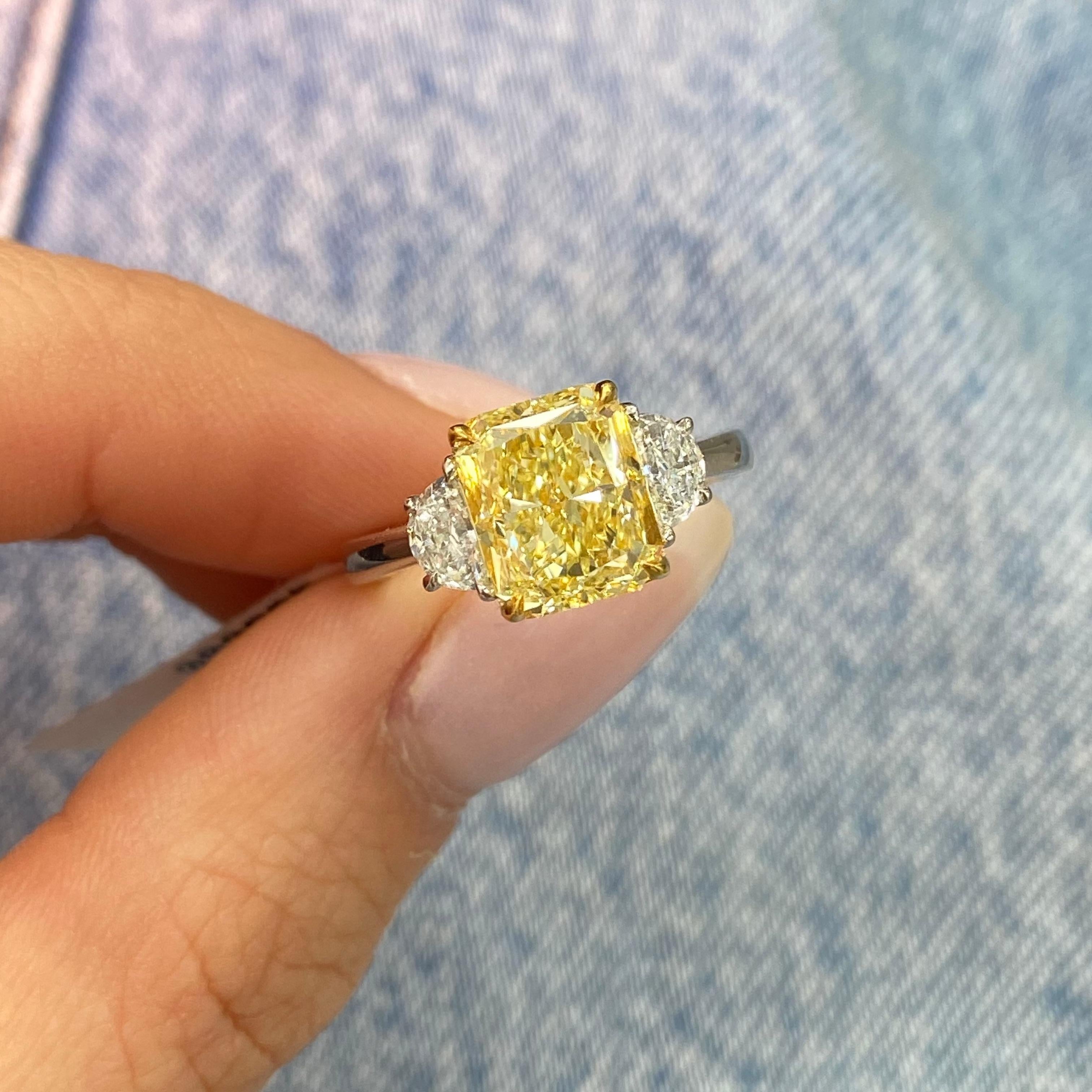 Experience the allure of rare beauty with this 3.29ct Fancy Yellow Elongated Radiant Diamond Three-Stone Ring. The centerpiece, a breathtaking elongated radiant-cut fancy yellow diamond, captures the eye with its vibrant hue and exceptional clarity.