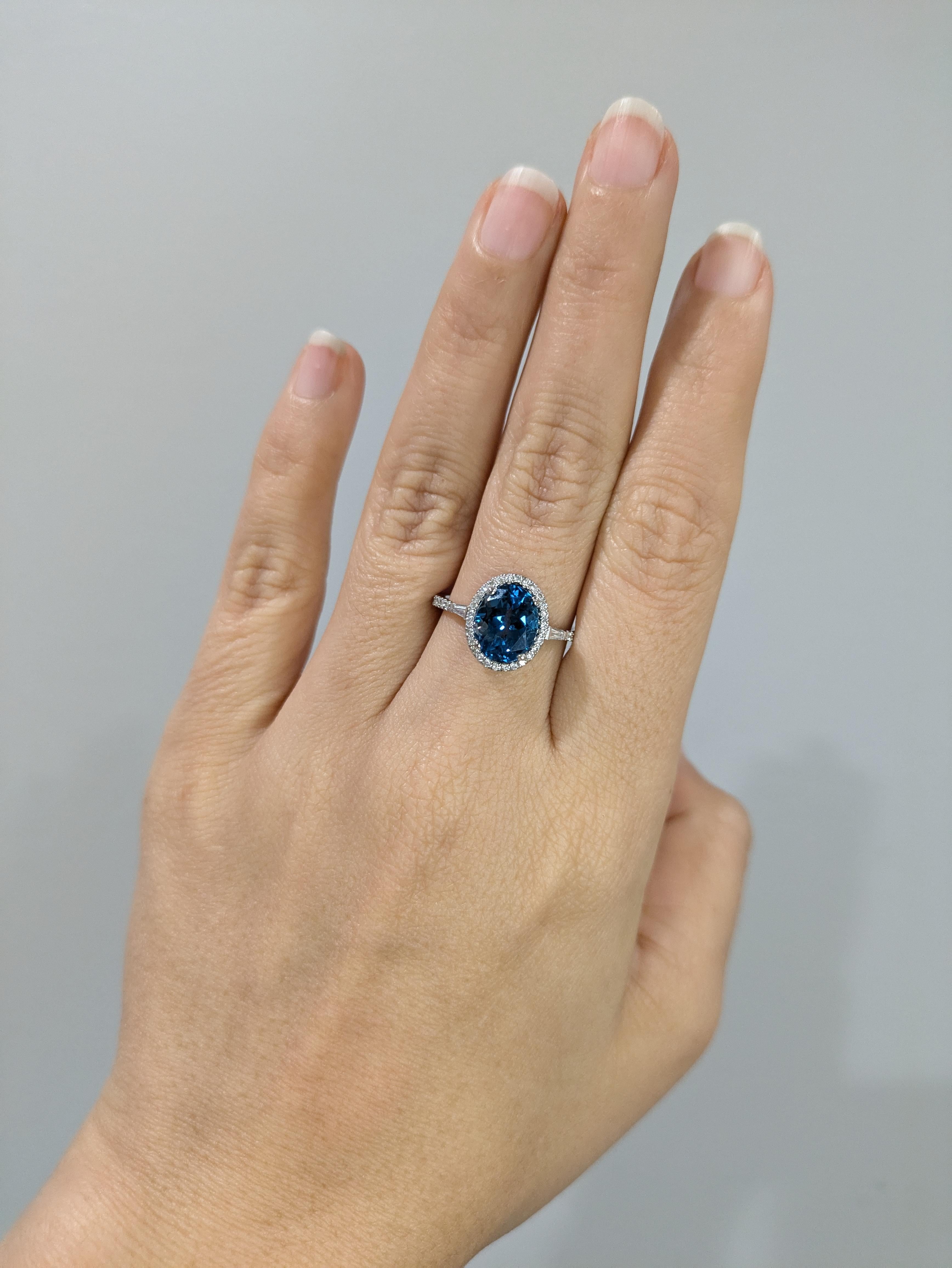 Questo bellissimo anello presenta un topazio blu di Londra da 3,22 carati in oro giallo 14k con una piccola aureola di diamanti naturali estratti dalla terra. Un anello dal design deciso, perfetto per un fidanzamento o un anniversario che attiri