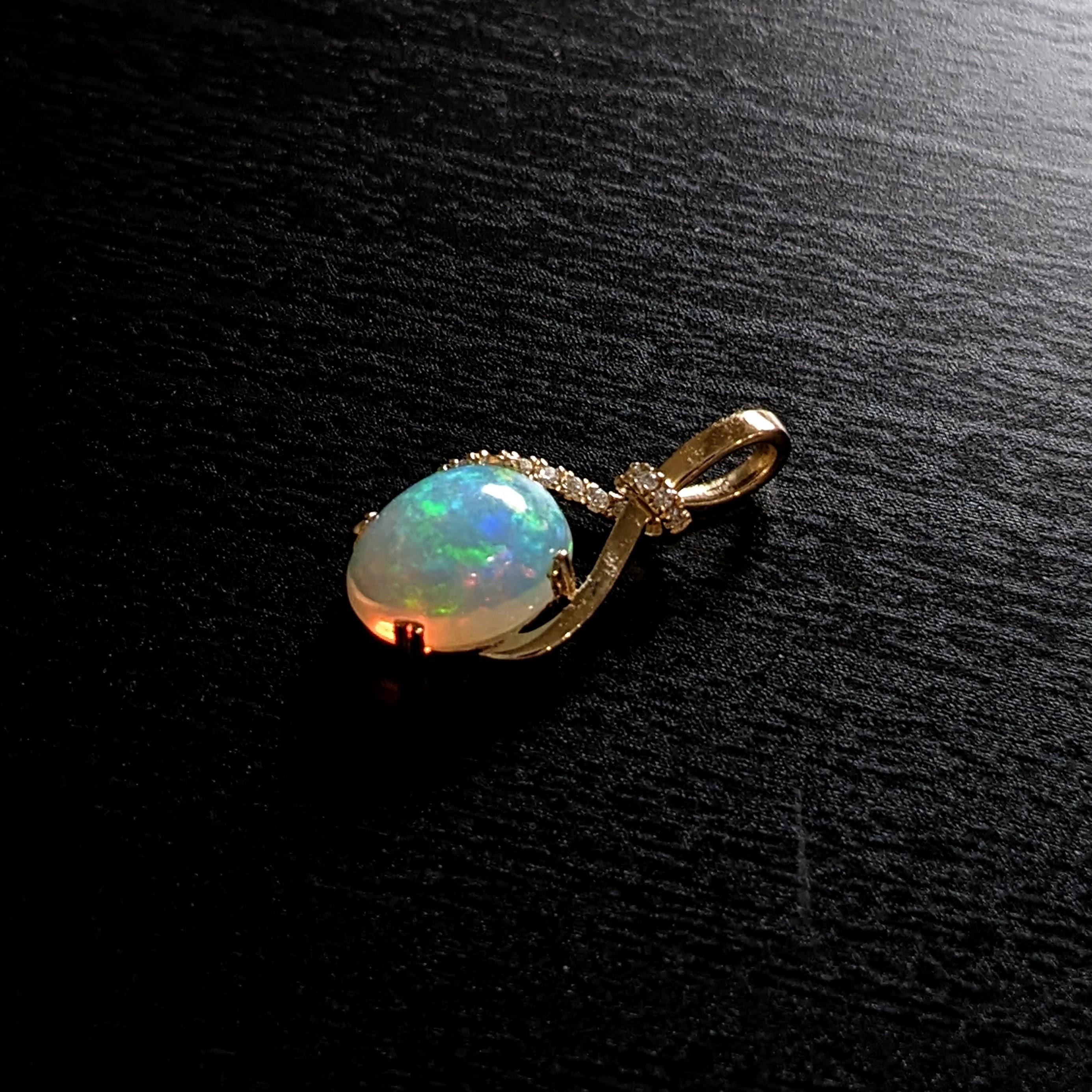Dieser wunderschöne Unendlichkeitsanhänger besteht aus einem ovalen Opal von 3,29 Karat und natürlichen, in der Erde geförderten Diamanten, die in massivem 14-karätigem Gold gefasst sind. Dieser Anhänger ist ein wunderschönes Geschenk für Ihre
