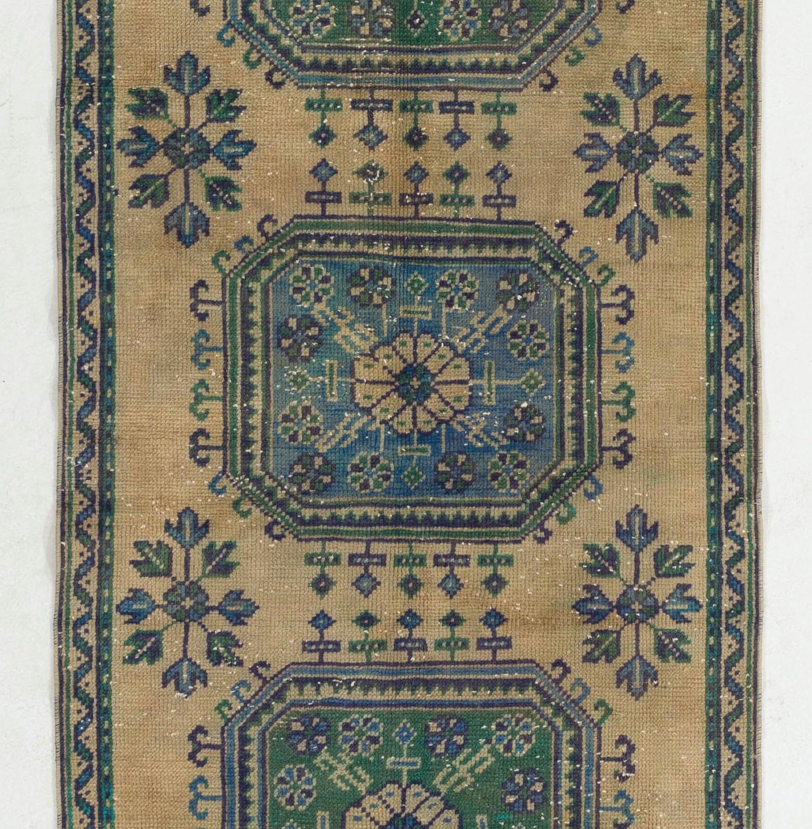 A vintage Turkish runner rug in beige, blue and beautiful hues of green. Finely hand-knotted with even medium wool pile on cotton foundation. In very good condition. Washed professionally. 
Sturdy and can be used on a high traffic area, suitable for