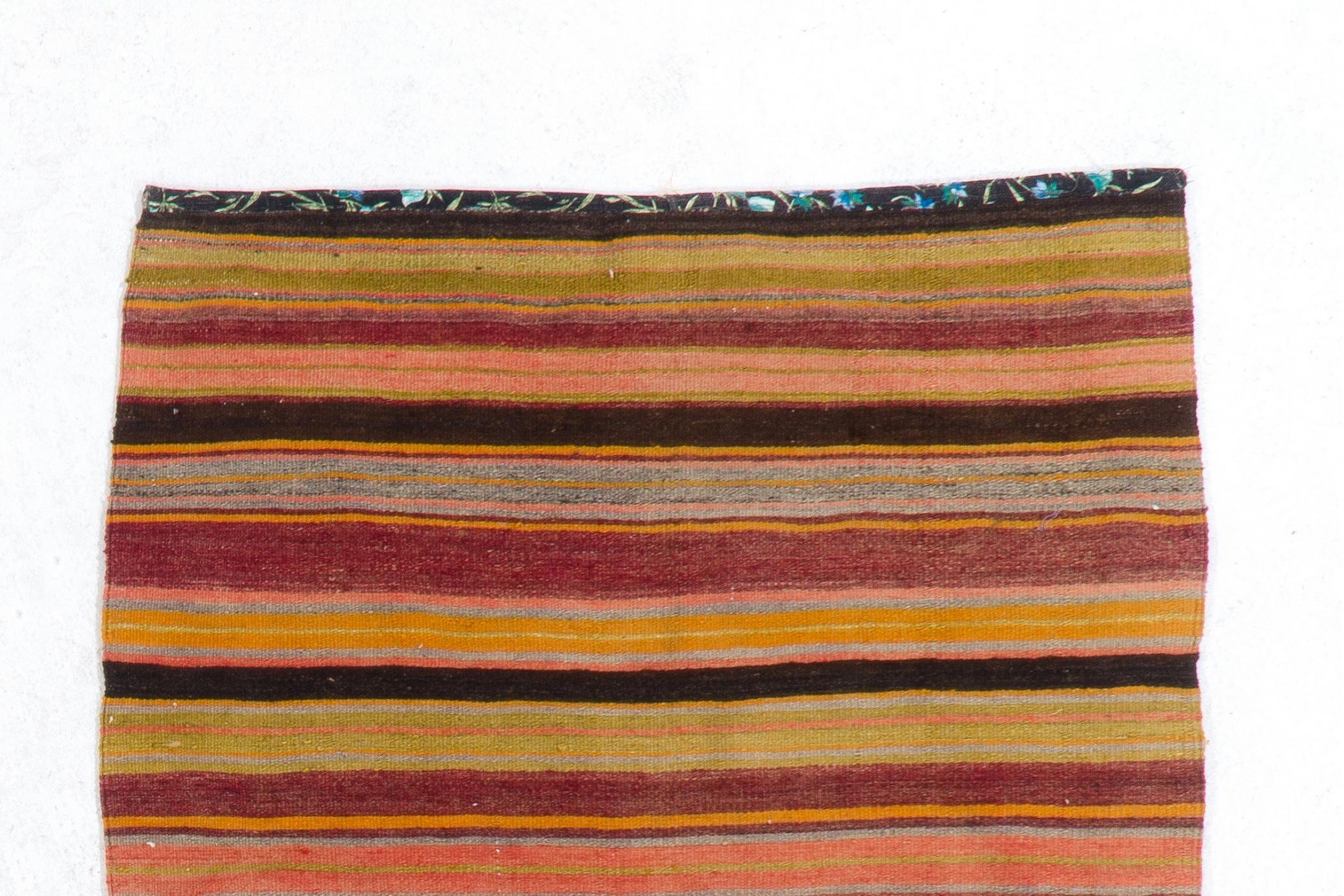 Vintage handwoven Turkish accent kilim/flat-weave with stripes in a rainbow of warm, lively colors including burgundy, peach, orange, grass green, light blue and dark brown. Made with 100% organic sheep's wool.

It is in good condition with no