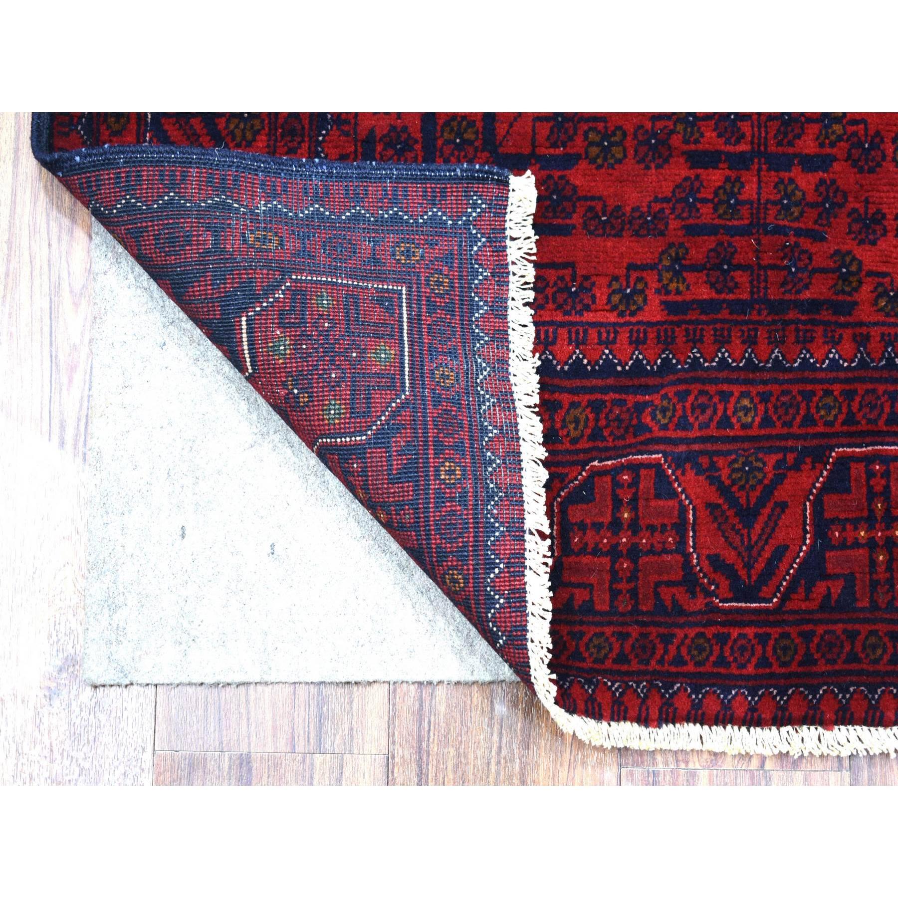Si tratta di un autentico esemplare unico di rosso intenso e saturo con tocchi di blu, lana vellutata annodata a mano, Khamyab afgano con design geometrico, tappeto orientale. È stato annodato per mesi e mesi con una tecnica artigianale di tessitura