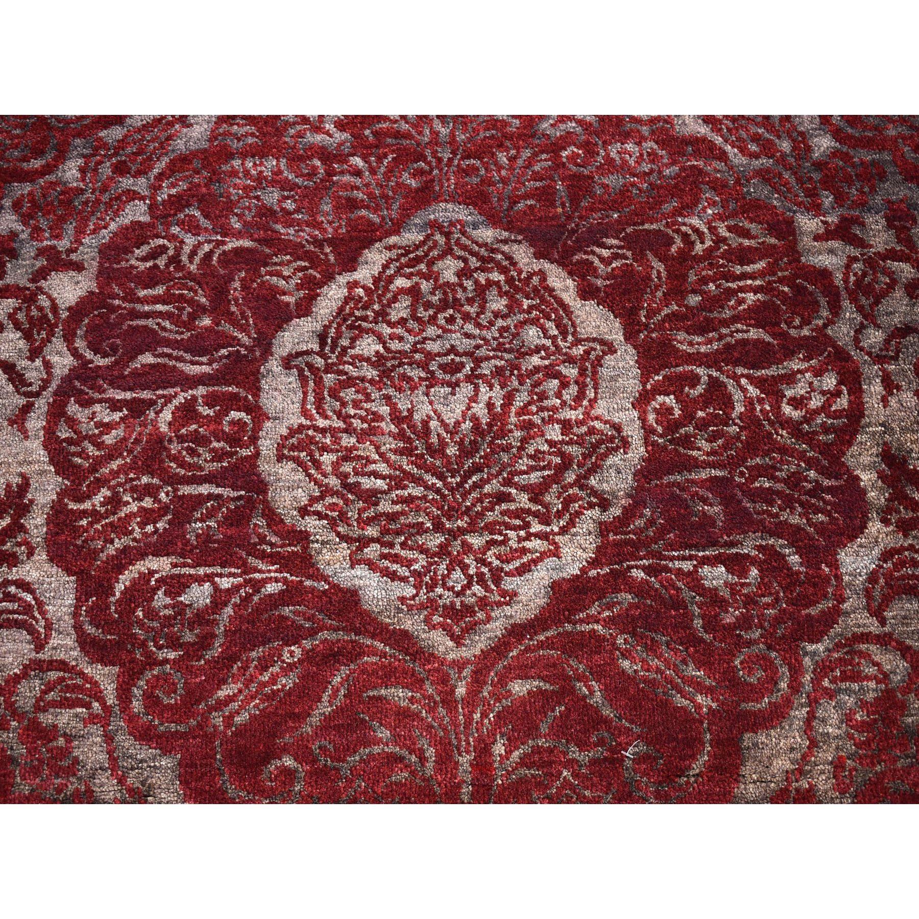 Si tratta di un autentico tappeto orientale in lana e seta nepalese dal design a fiore di loto grande annodato a mano di colore rosso bordeaux. È stato tessuto per mesi e mesi secondo le secolari tecniche di tessitura persiane da esperti