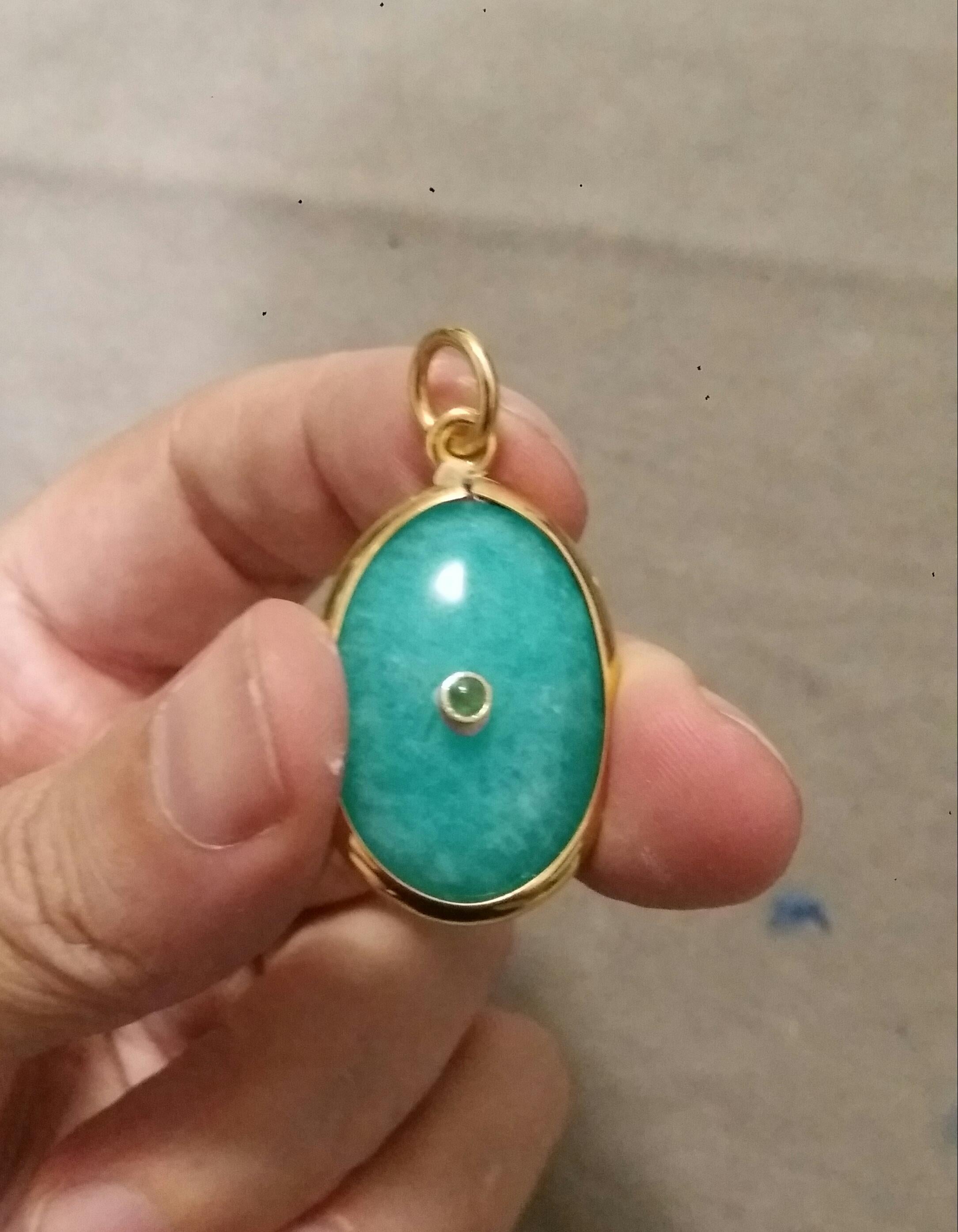33 Carats Oval Amazonite Cabochon measuring 20x30 mm set as a Pendant in 14kt yellow gold bezel with in the center a small round Emerald Cab set  in 14K yellow gold bezel .