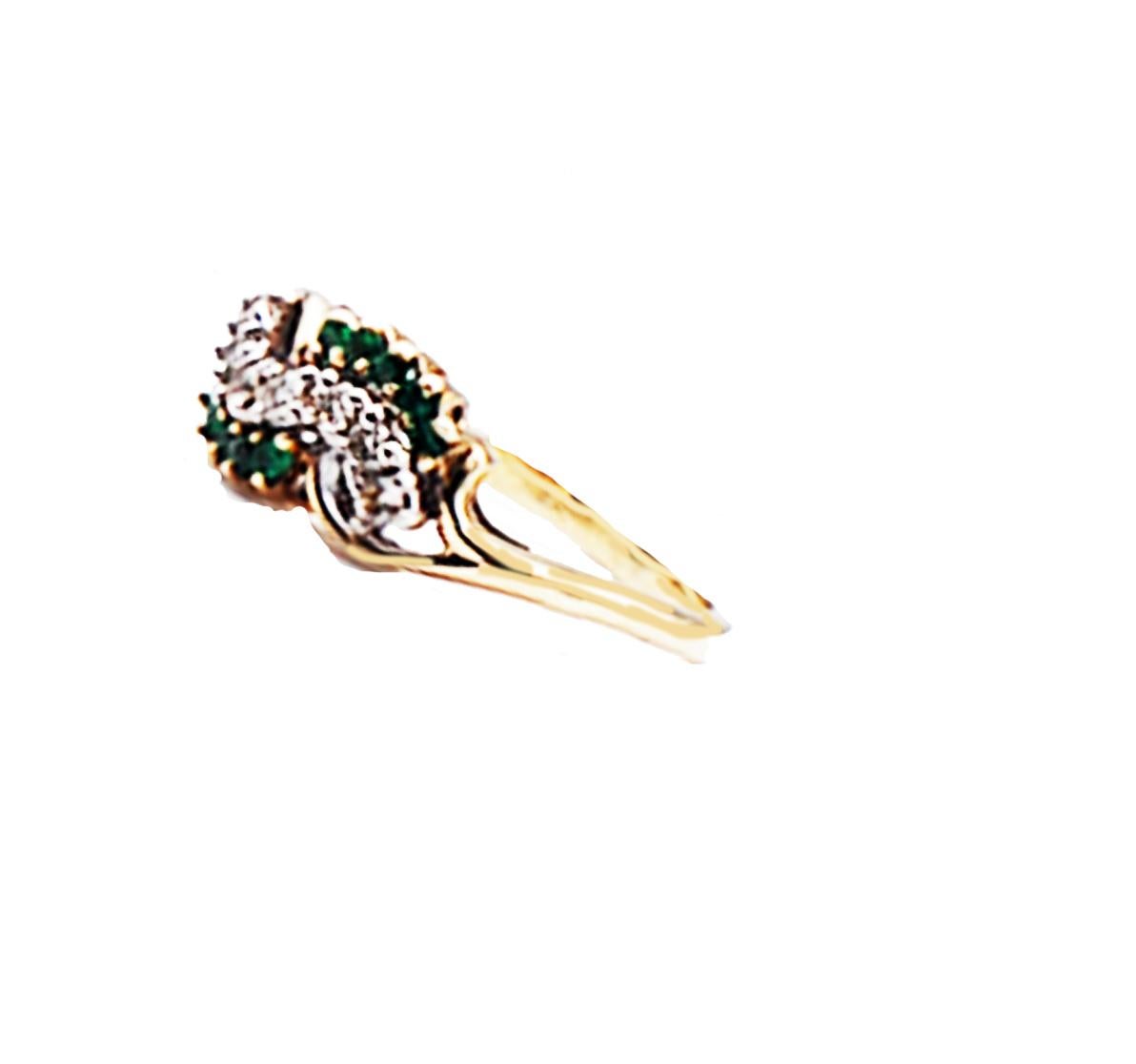 Cluster diamond and vibrant colored emerald ring is nicely arranged on this 'wave' style ring and hugs the finger giving a lovely statement. 
The ring measures .50 inches across and .30 inches wide.
The center has (7) round diamonds measuring 1.35