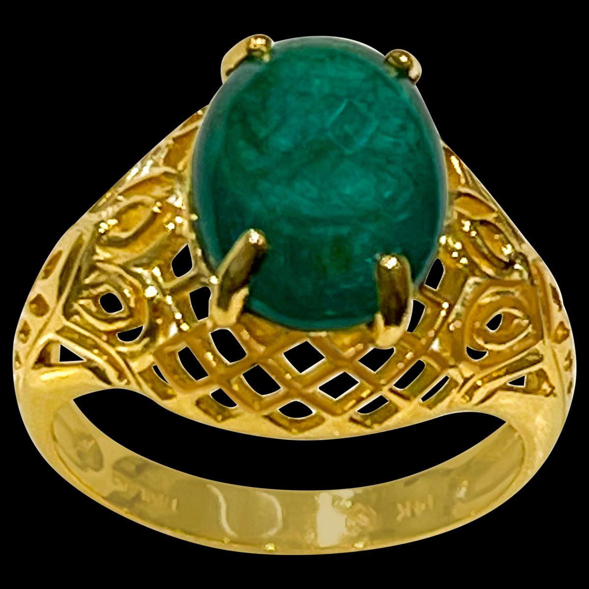 A classic, Cocktail ring 
 Emerald  cabochon approximately 3.3 Carat Emerald , Estate with no color enhancement. 
Color is extremely   pretty but as all natural emeralds have inclusions , this one also has inclusions.
Gold: 14 Karat Yellow  gold